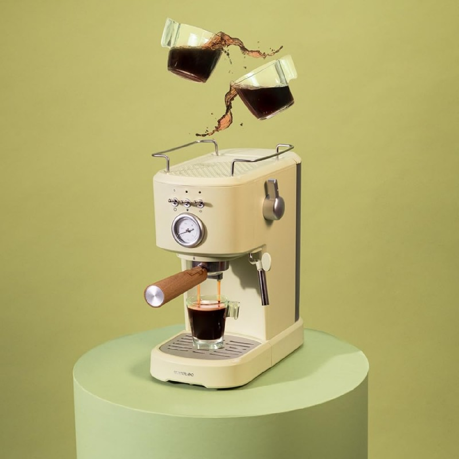 Kremowy ekspres do kawy z kawą wlewaną do szklanki. Dwie szklanki z kawą unoszą się nad nią.