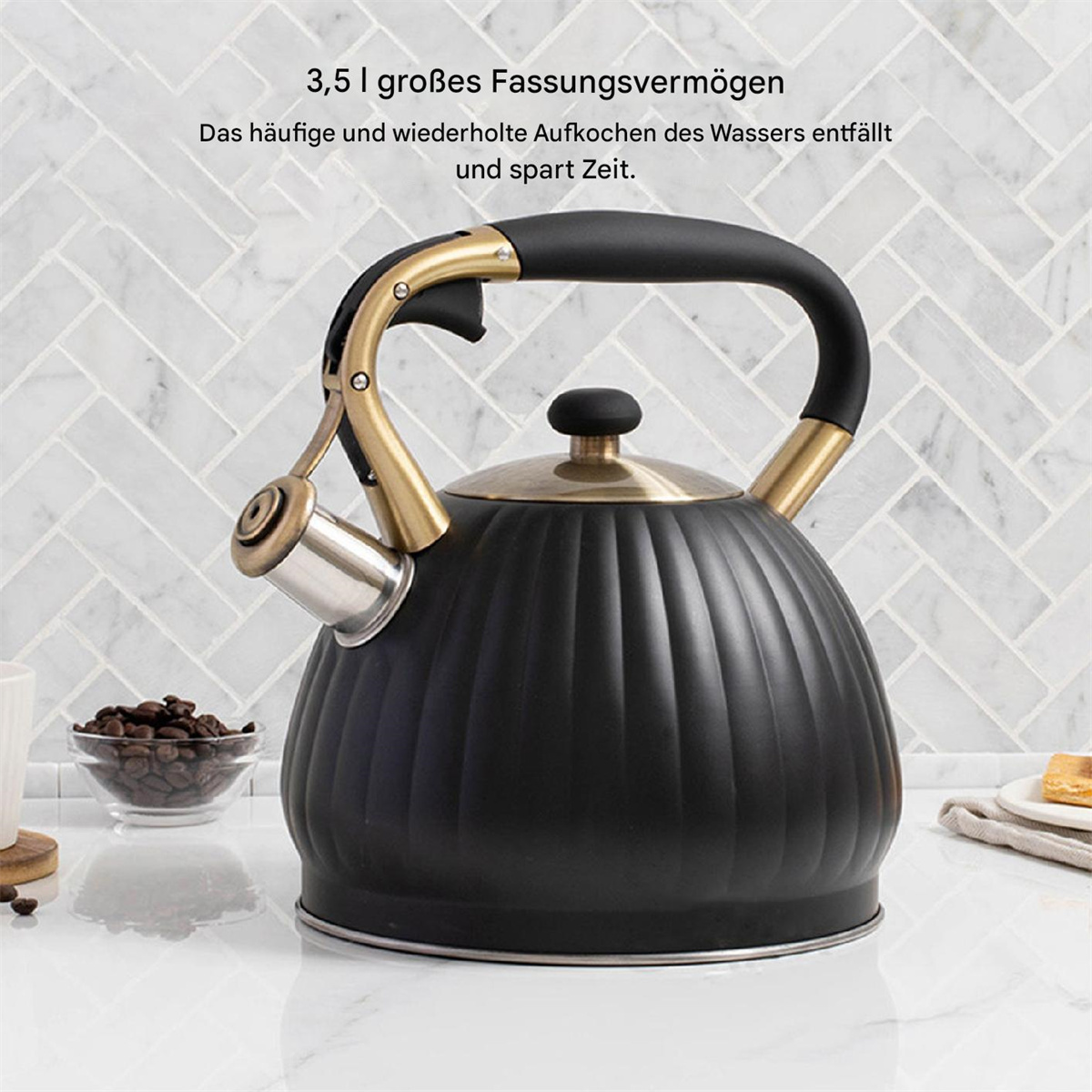 Schwarzer Wasserkocher mit Griff und Ausguss, auf weißer Oberfläche, mit Kaffeebohnen.