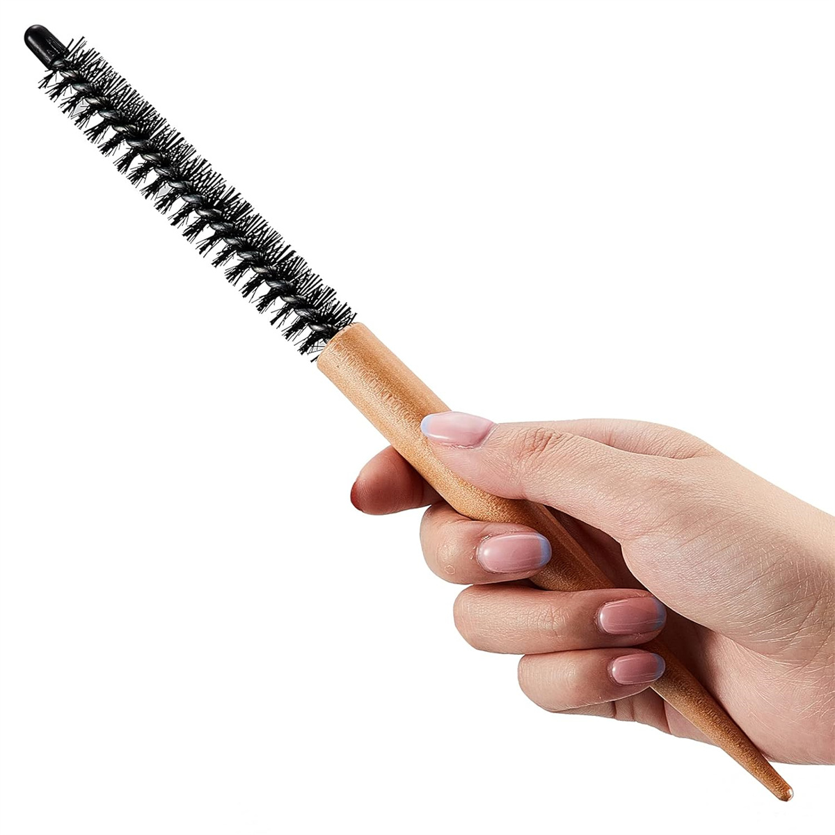 Eine Hand hält eine runde Haarbürste. Die Bürste hat schwarze Borsten und einen Holzgriff. Die Nägel sind rosa.