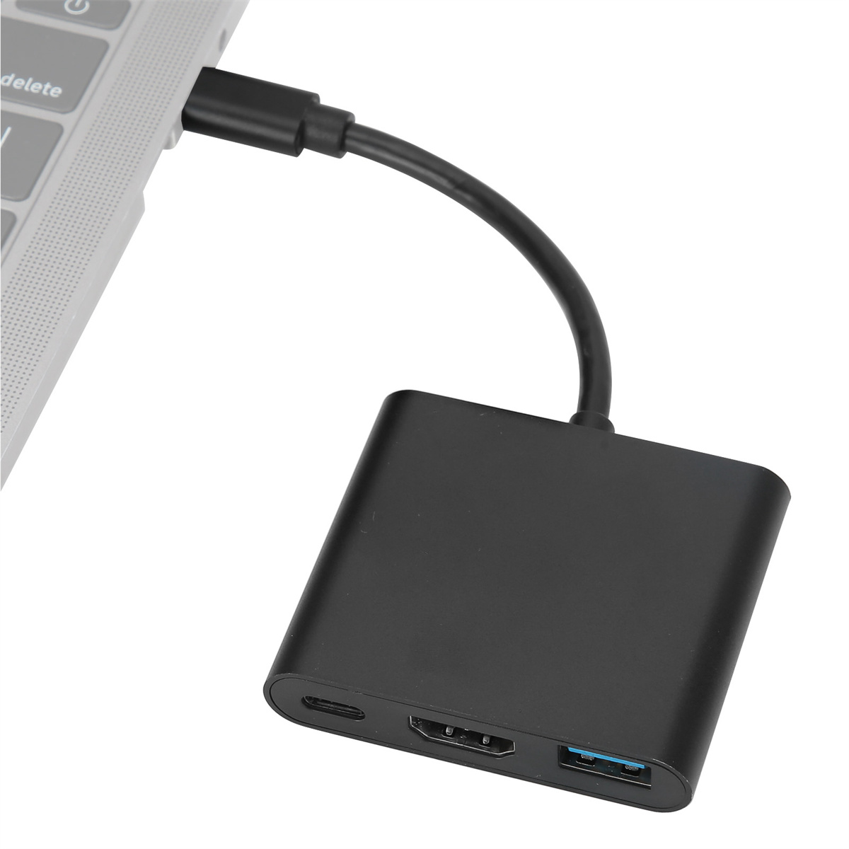 Schwarzer Adapter, verbunden mit Laptop. USB-, HDMI- und USB-C-Anschlüsse. Schwarzes Kabel.