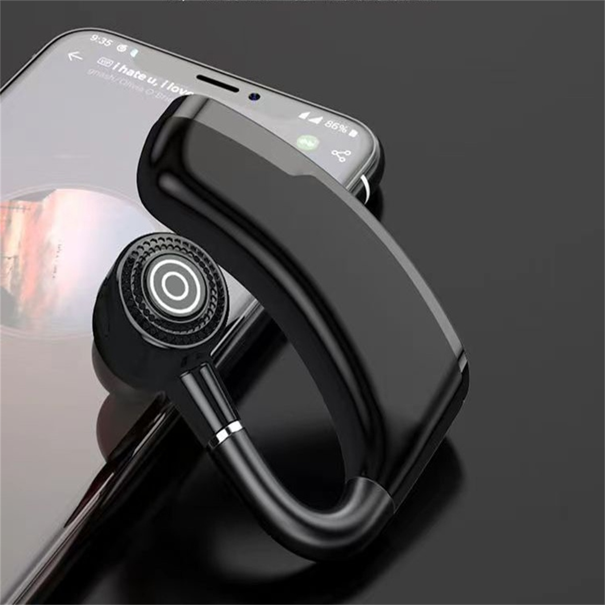 Schwarzes Bluetooth-Headset auf einem schwarzen Smartphone.