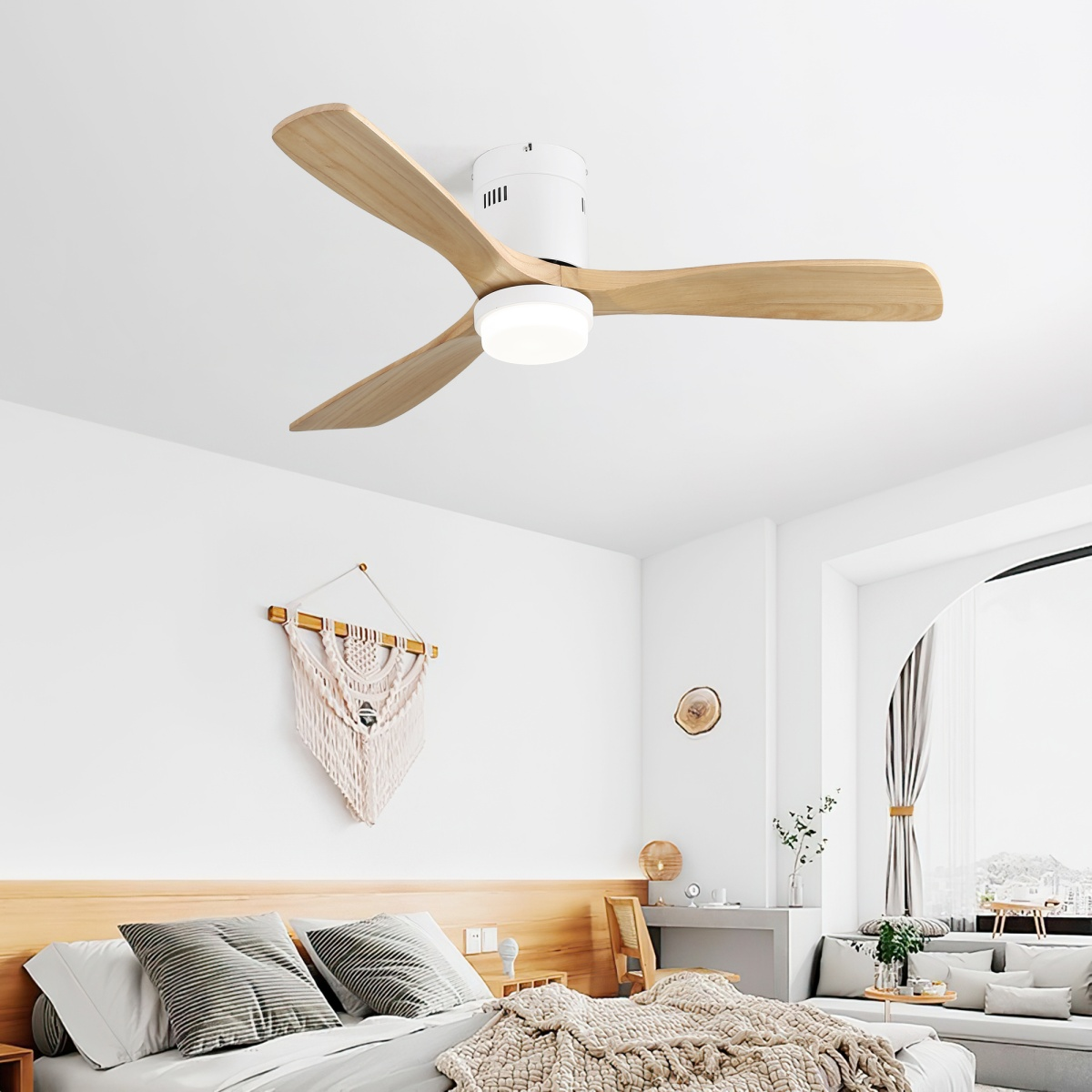 Ein Deckenventilator mit Holzflügeln und einer weißen Leuchte in einem Schlafzimmer.