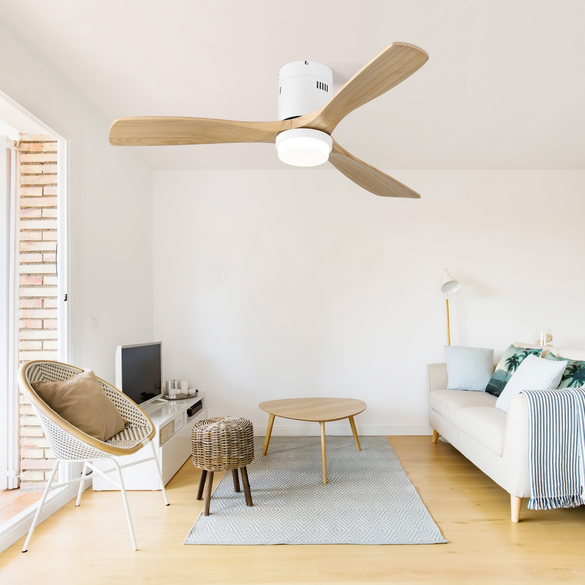 Ein modernes Wohnzimmer mit Deckenventilator, weißen Wänden, Sofa und Holzböden.