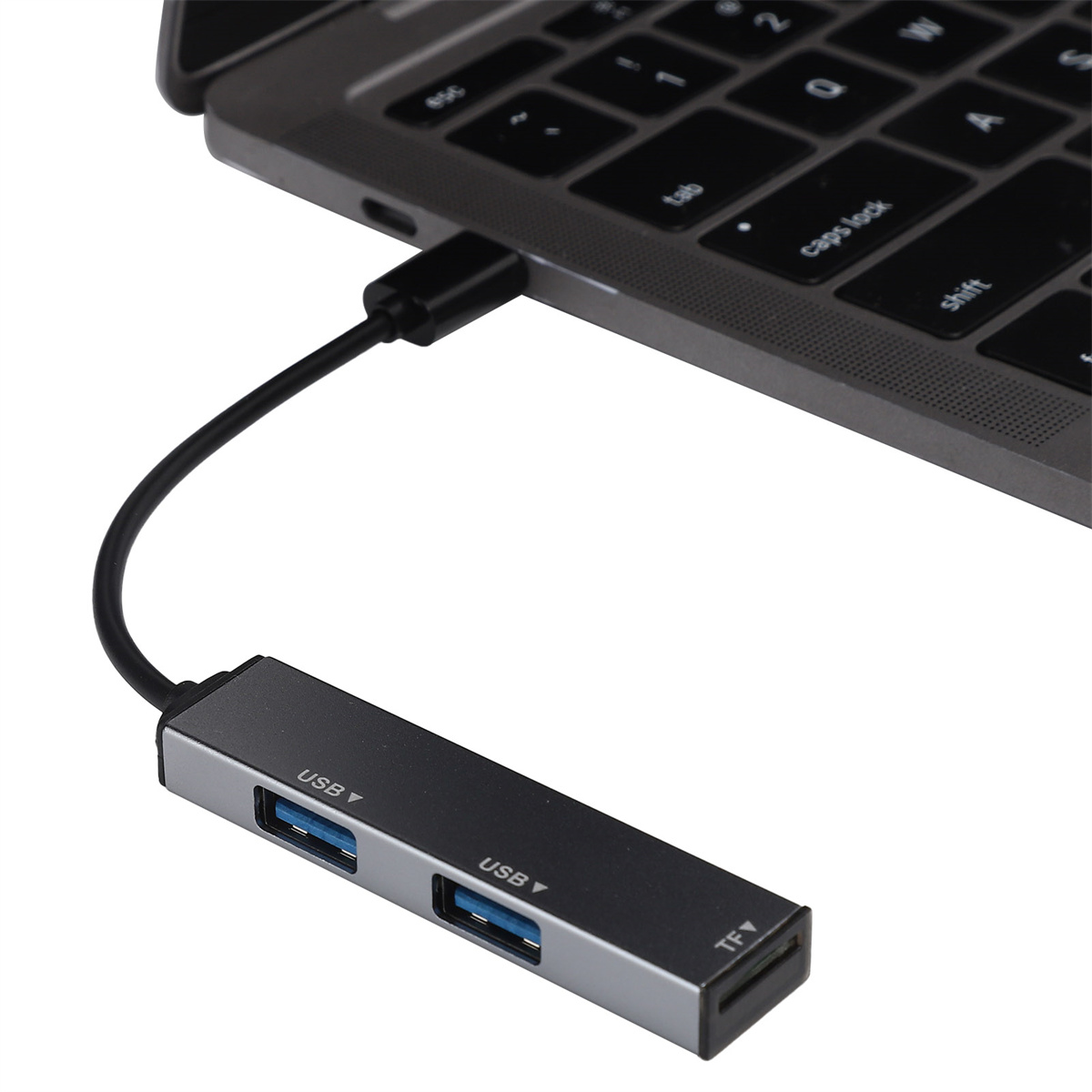 Ein silberner USB-Hub, der mit einem Laptop verbunden ist. Es hat USB und einen TF-Steckplatz.