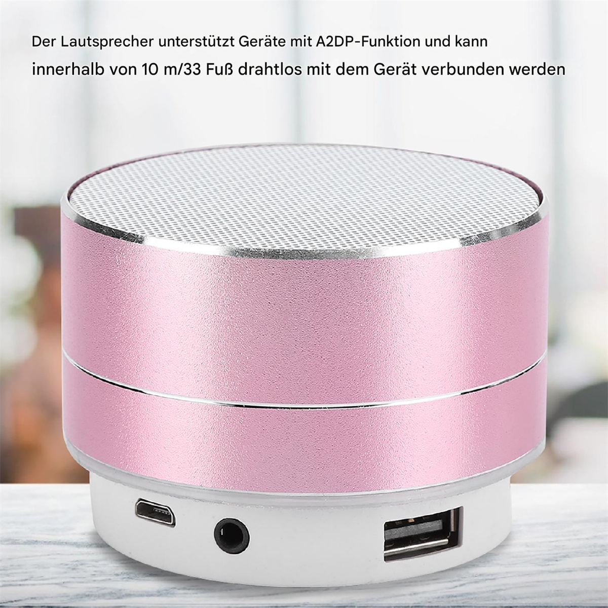 Rosa und silberner Lautsprecher mit Mesh-Oberseite und Anschlüssen unten.