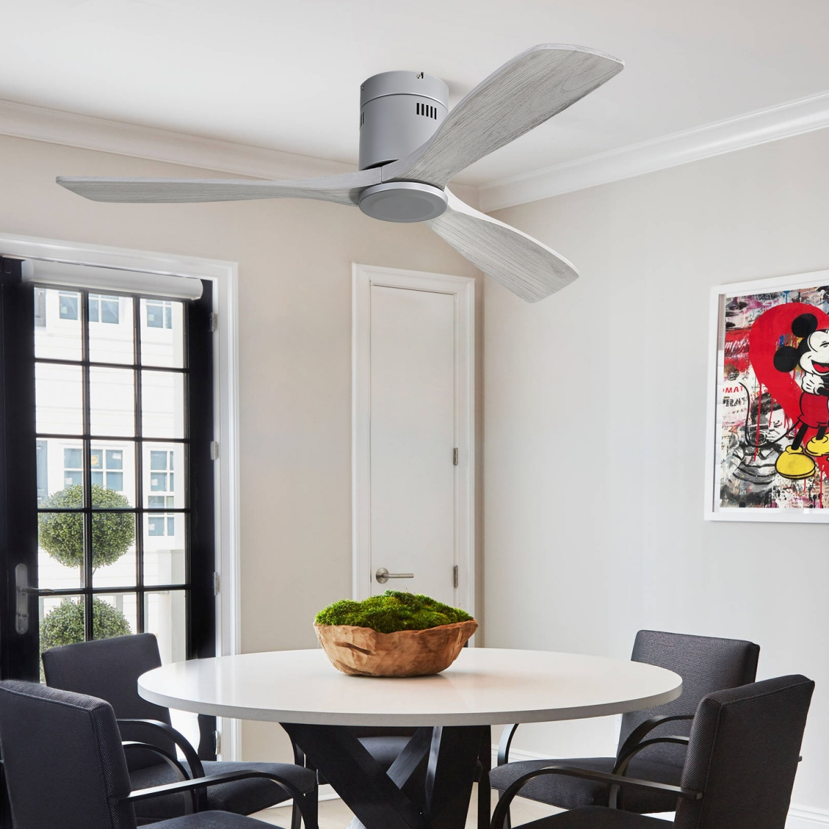 Esszimmer mit rundem Tisch, Stühlen und Deckenventilator.
