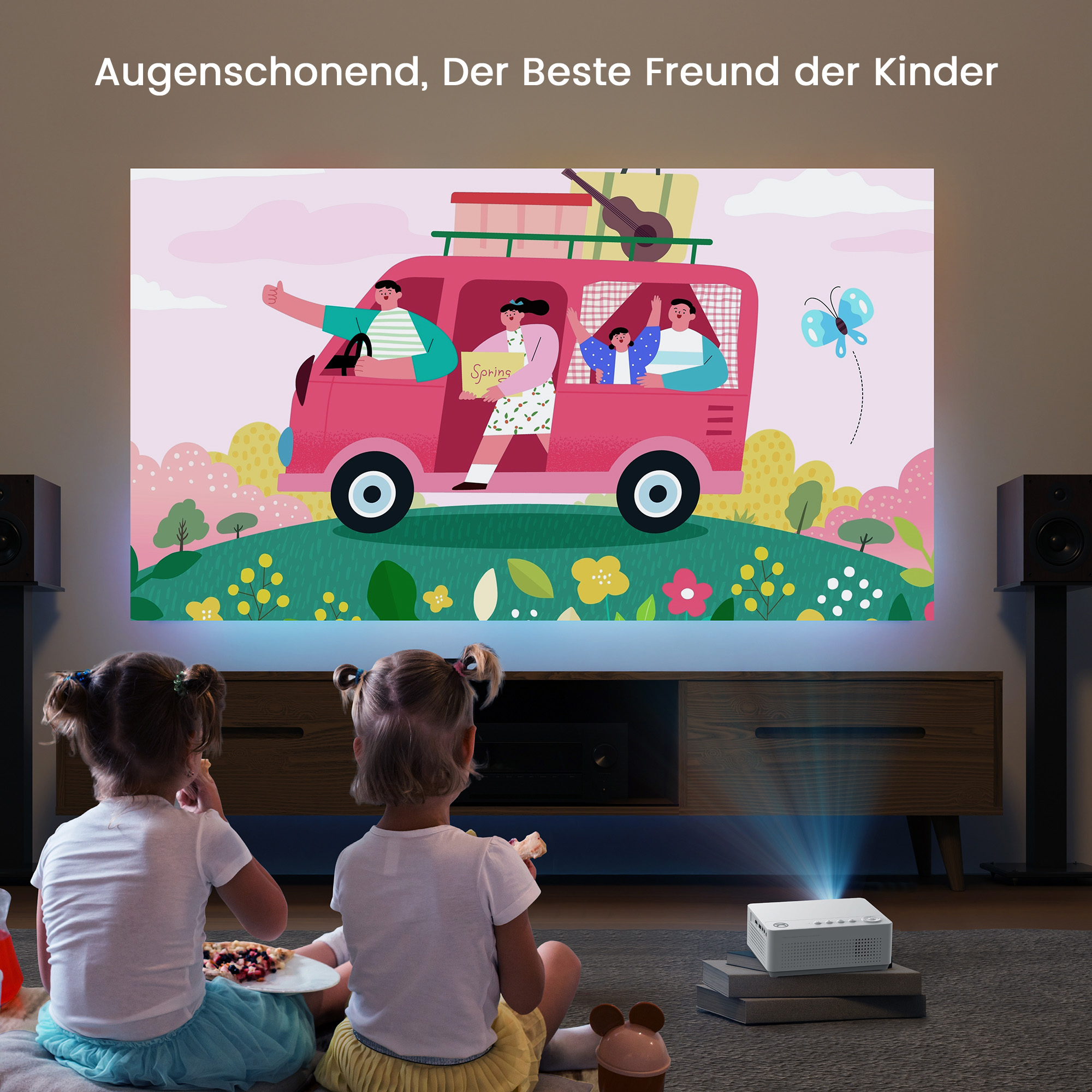 Zwei Mädchen sehen sich einen Projektor an, der ein Auto mit Personen zeigt. Weißer Projektor.