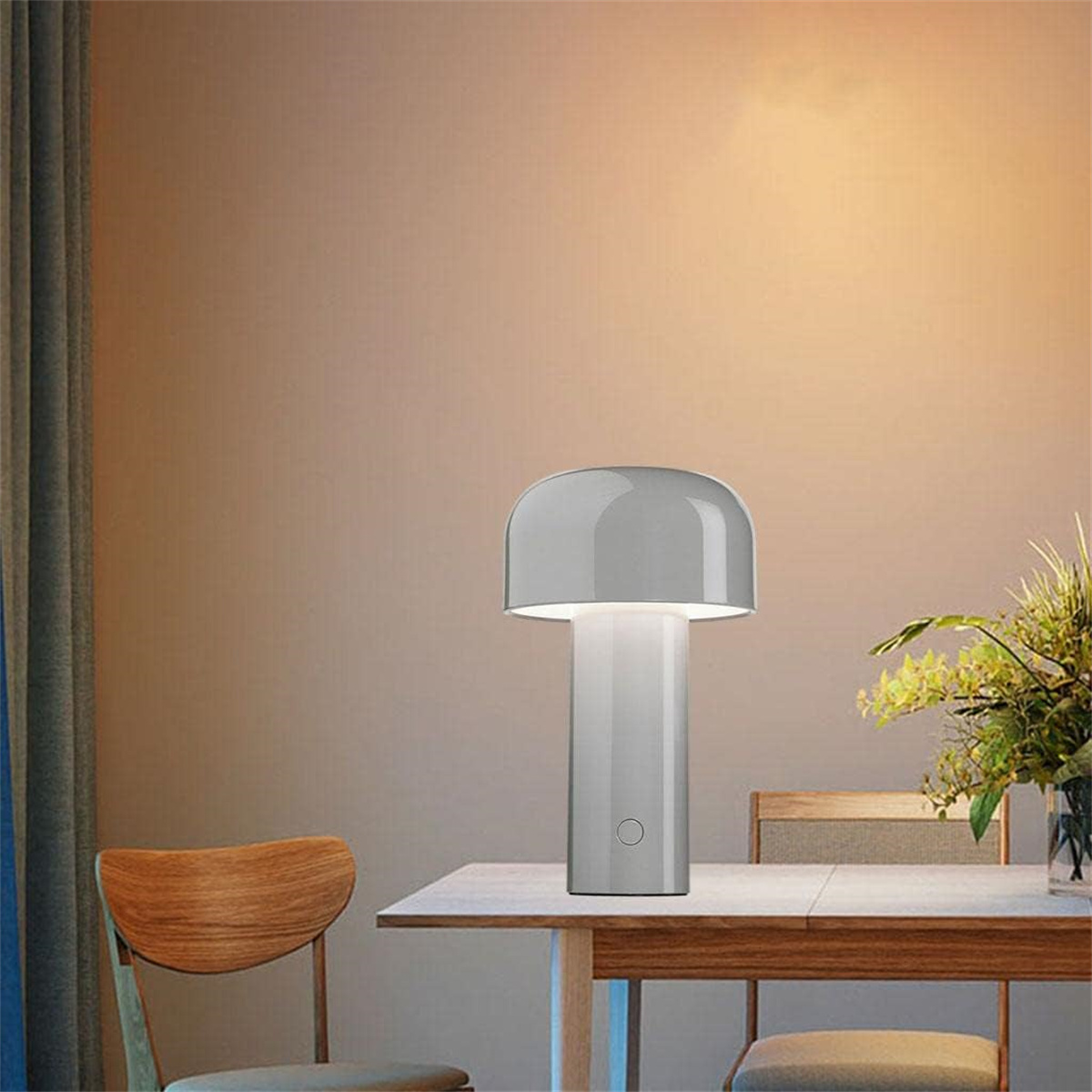 Eine grau-weiße pilzförmige Tischlampe auf einem Tisch mit Blumen.