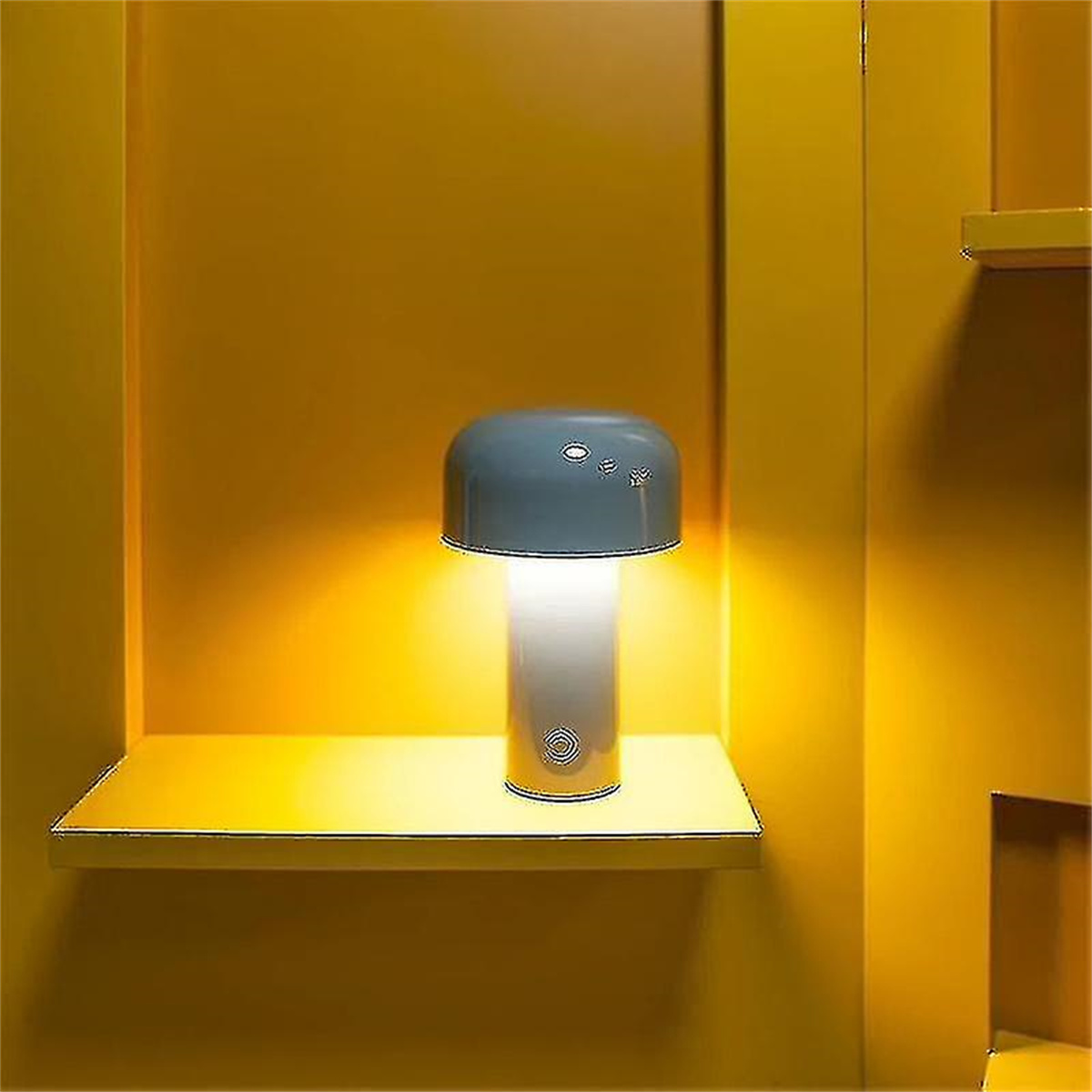 Pilzförmige Tischlampe auf gelbem Regal vor gelber Wand.