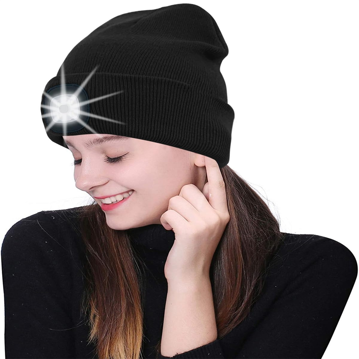 Eine Frau mit schwarzer Mütze und hellem LED-Licht lächelt und berührt ihr Ohr.
