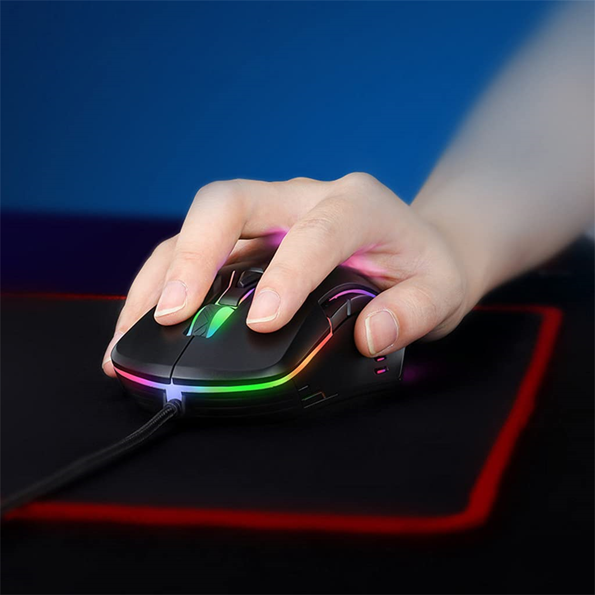 Eine Hand liegt auf einer schwarzen Gaming-Maus mit mehrfarbigen LED-Lichtern auf einem schwarzen Mausp.