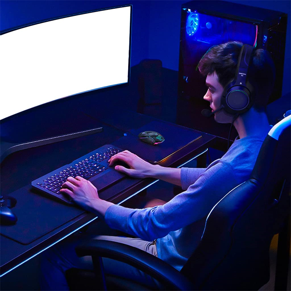 Ein Spieler sitzt an einem Schreibtisch, trägt ein Headset und spielt ein Spiel auf einem gebogenen Monitor.