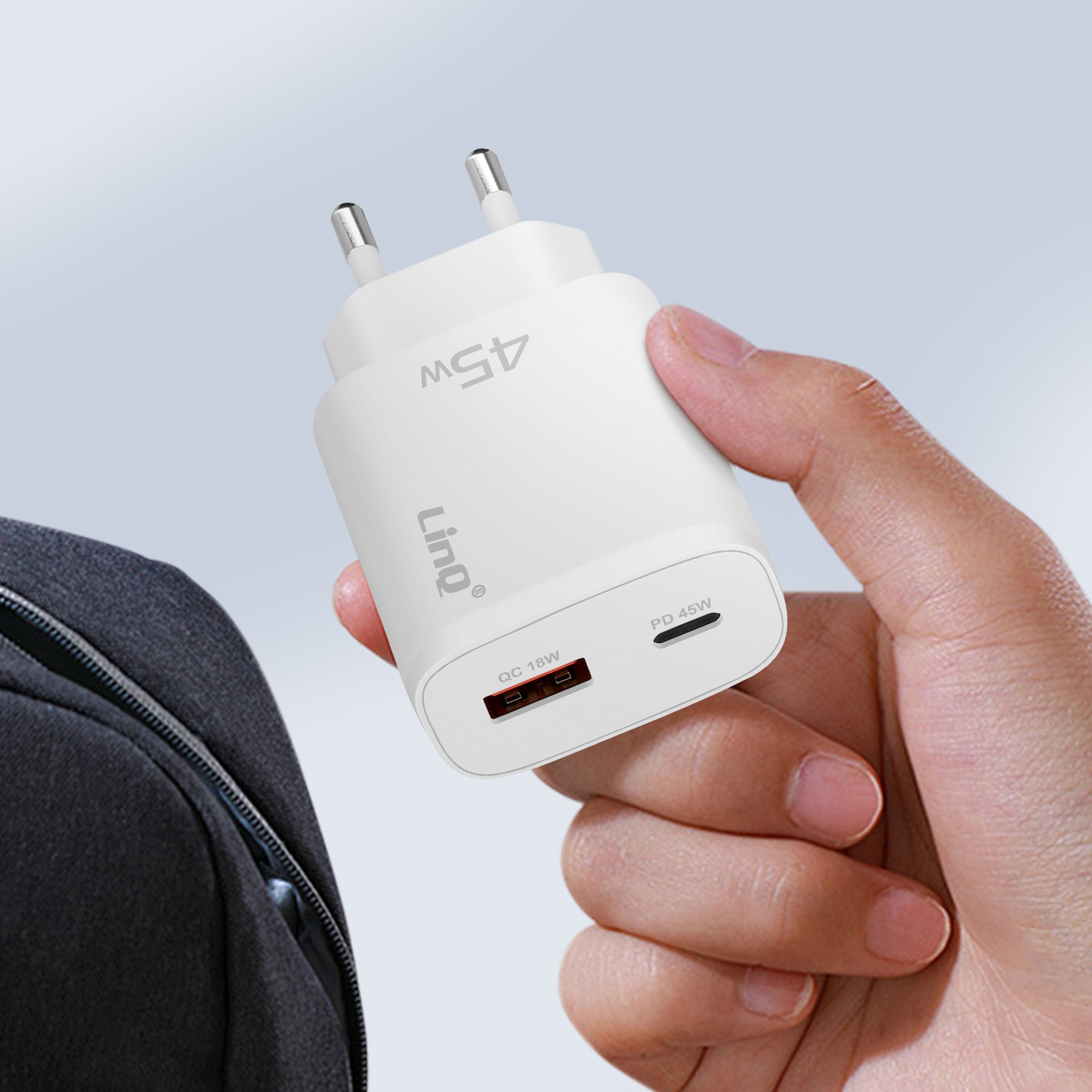 Hand hält weißes Ladegerät mit zwei USB-Anschlüssen. Das Ladegerät hat die Aufschrift 'PD 45W'.