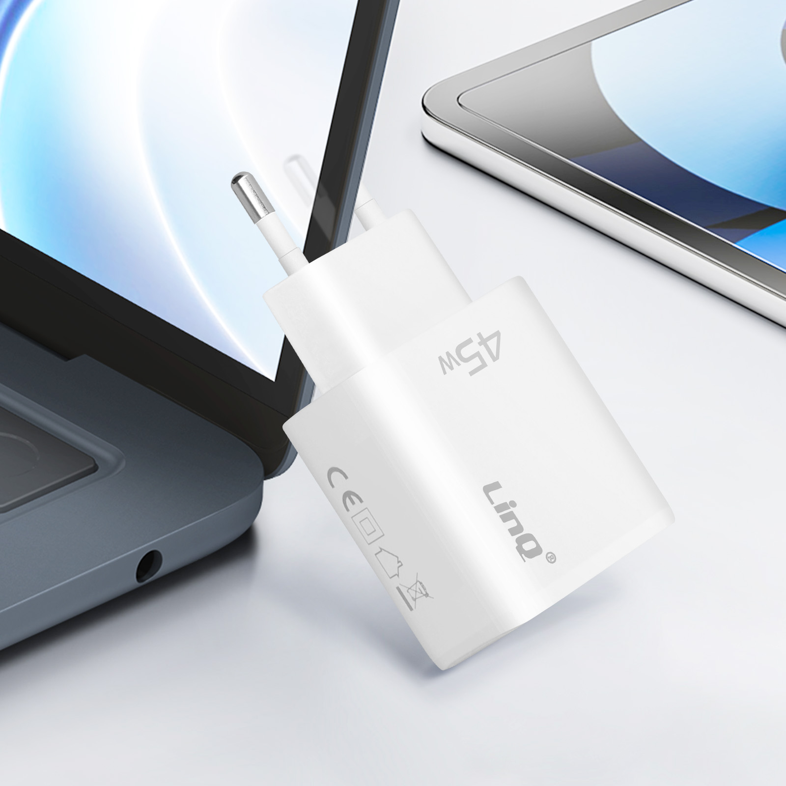 Ein weißes 45-W-Ladegerät mit USB-C-Anschluss ist an einem Laptop angeschlossen, und ein Tablet ist sichtbar.