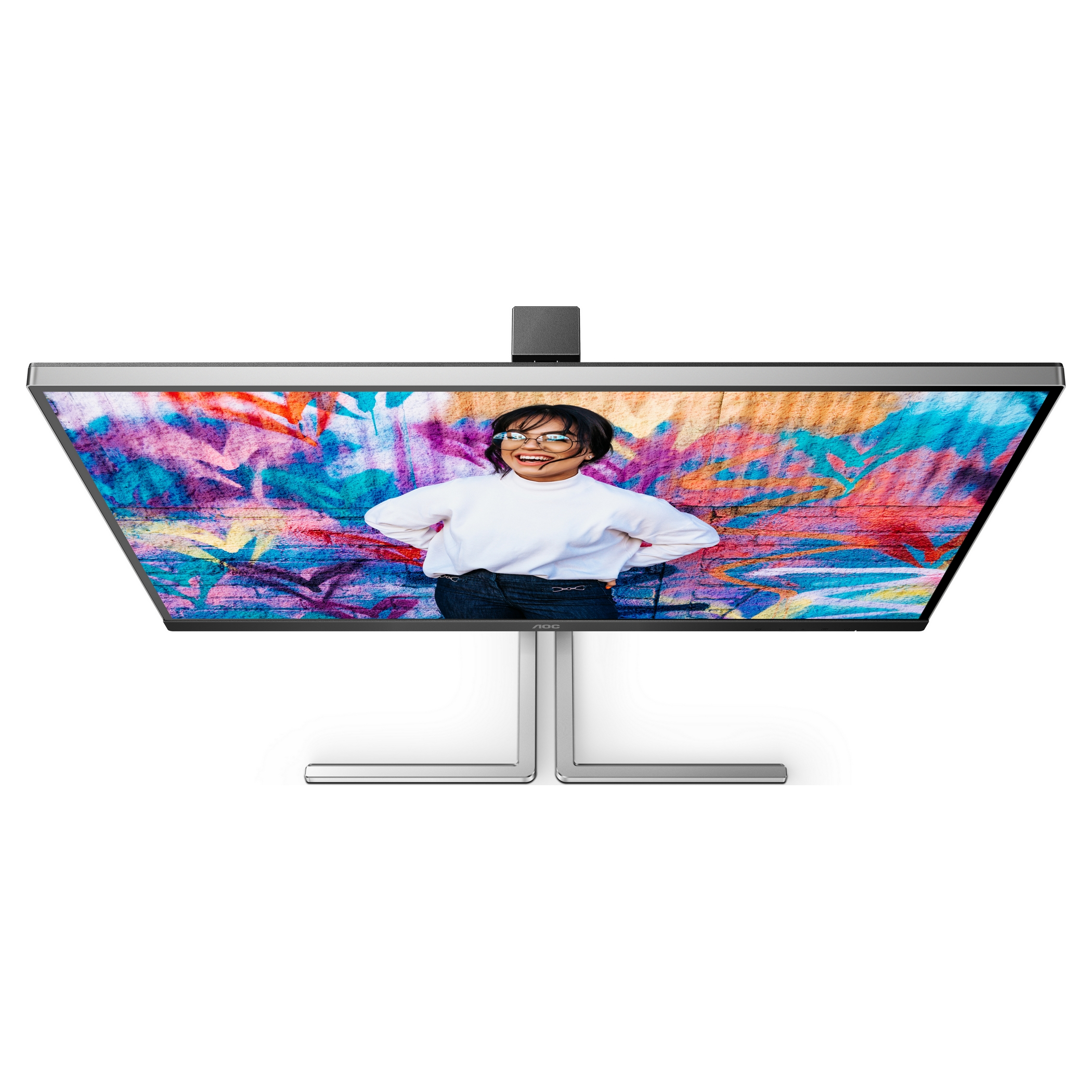 Monitor wyświetlający dziewczynę przed ścianą graffiti. Monitor ma srebrną ramkę.