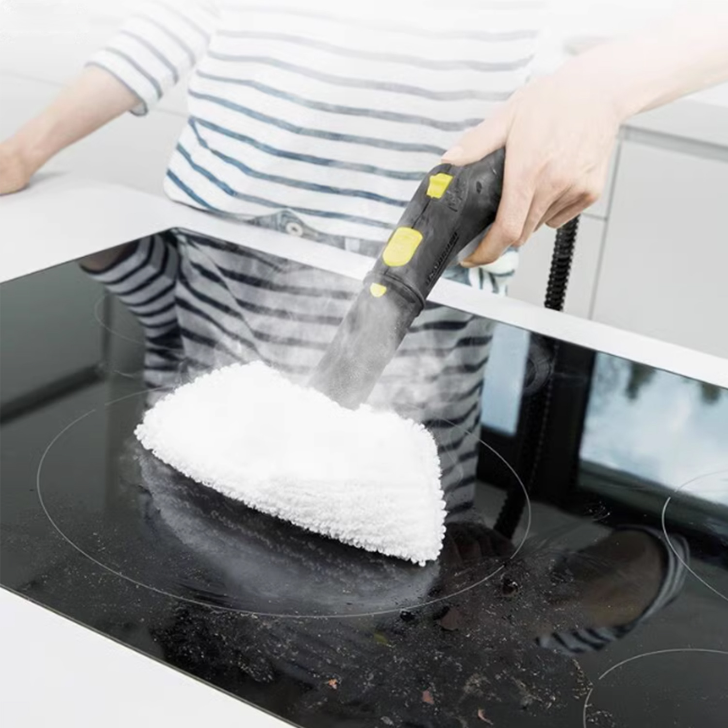 Osoba czyści brudną płytę kuchenną za pomocą parownicy ręcznej.