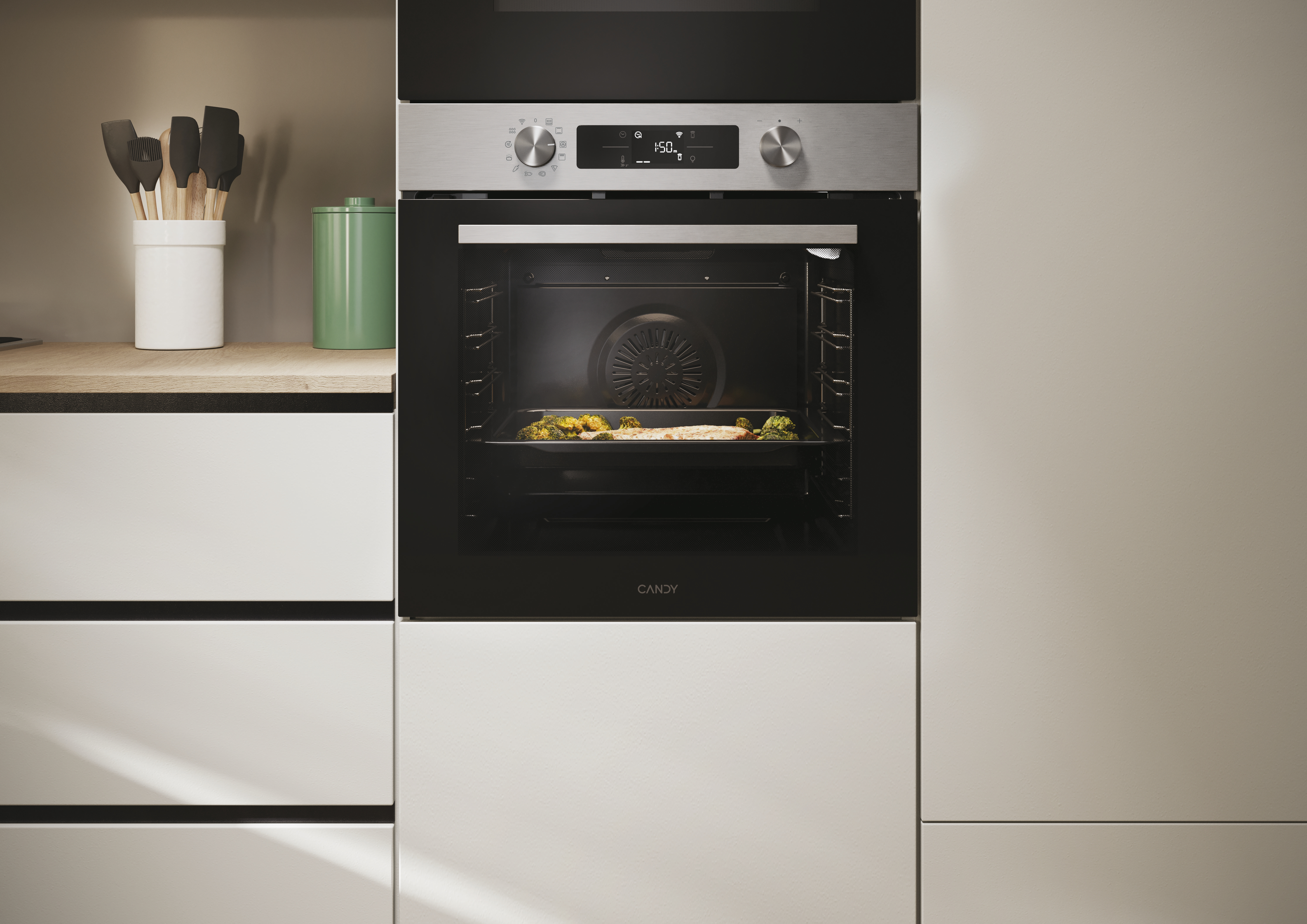 Un forno aperto con cibo all'interno. Sopra, due manopole e un display digitale. Sotto, un mobile bianco.