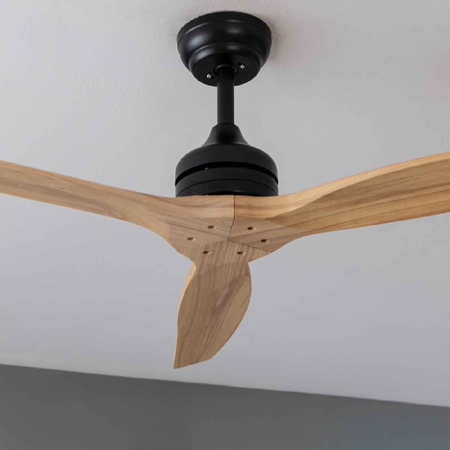 Ein schwarzer Deckenventilator mit Holzflügeln.