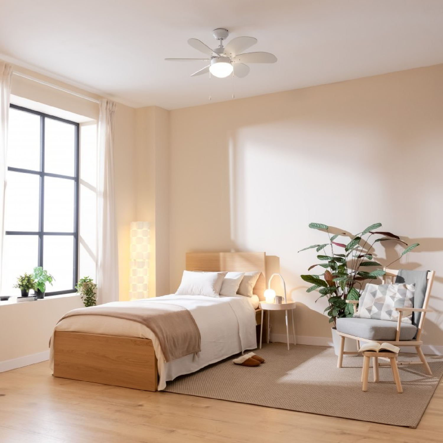 Schlafzimmer mit Bett, Fenster, Pflanzen und Deckenventilator. Der Raum ist hell beleuchtet.