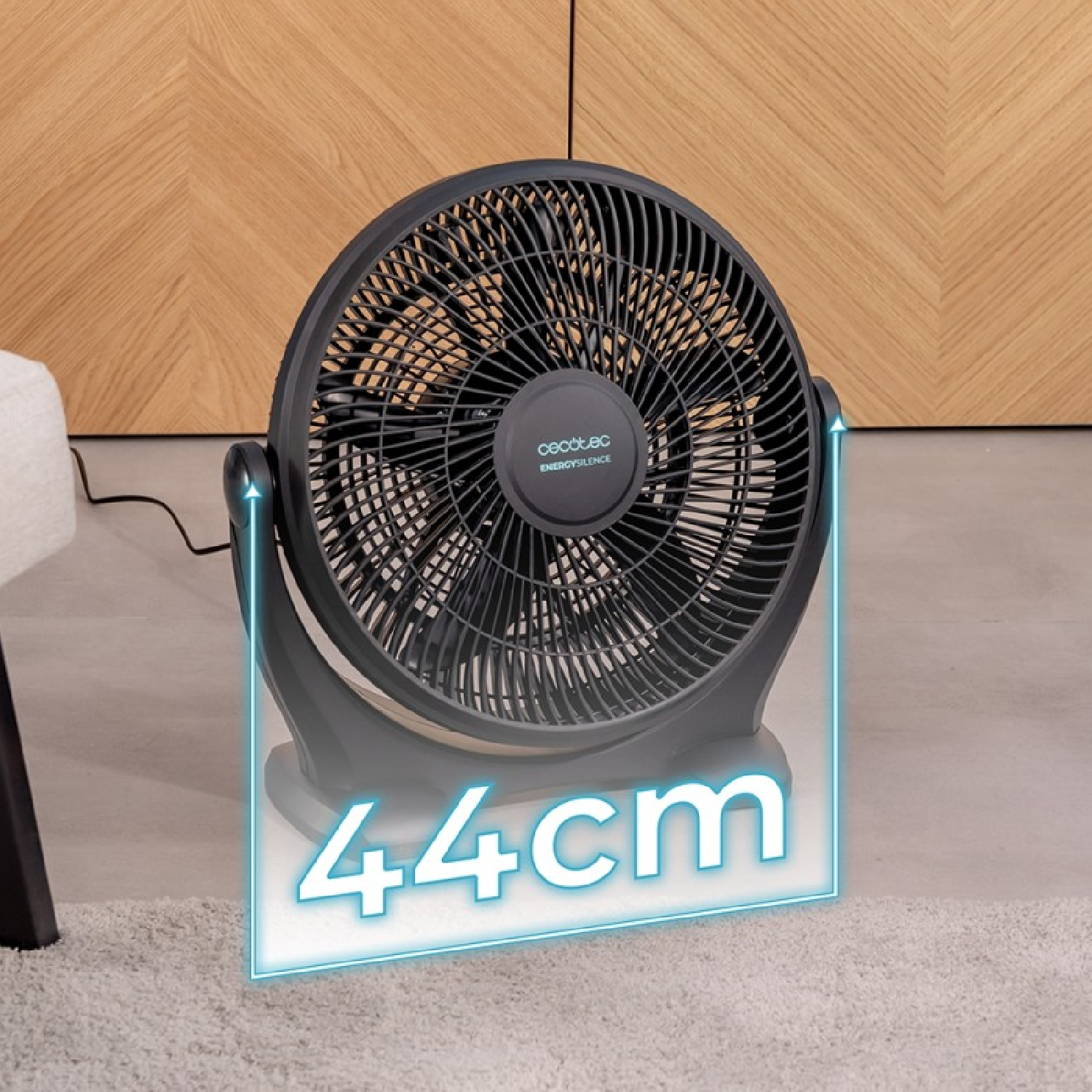 Schwarzer Ventilator mit blauer Umrandung, die 44 cm anzeigt. Ein Holzschrank im Hintergrund.