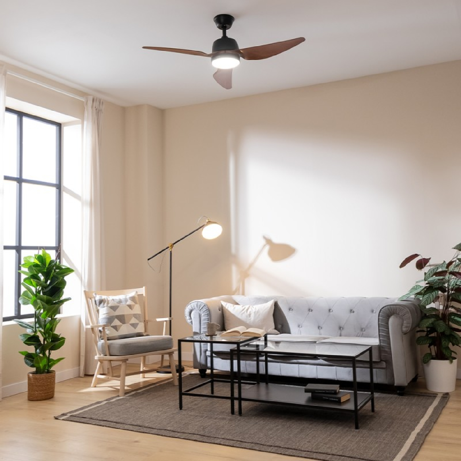 Salón con ventilador de techo, sofá, ventana y planta.