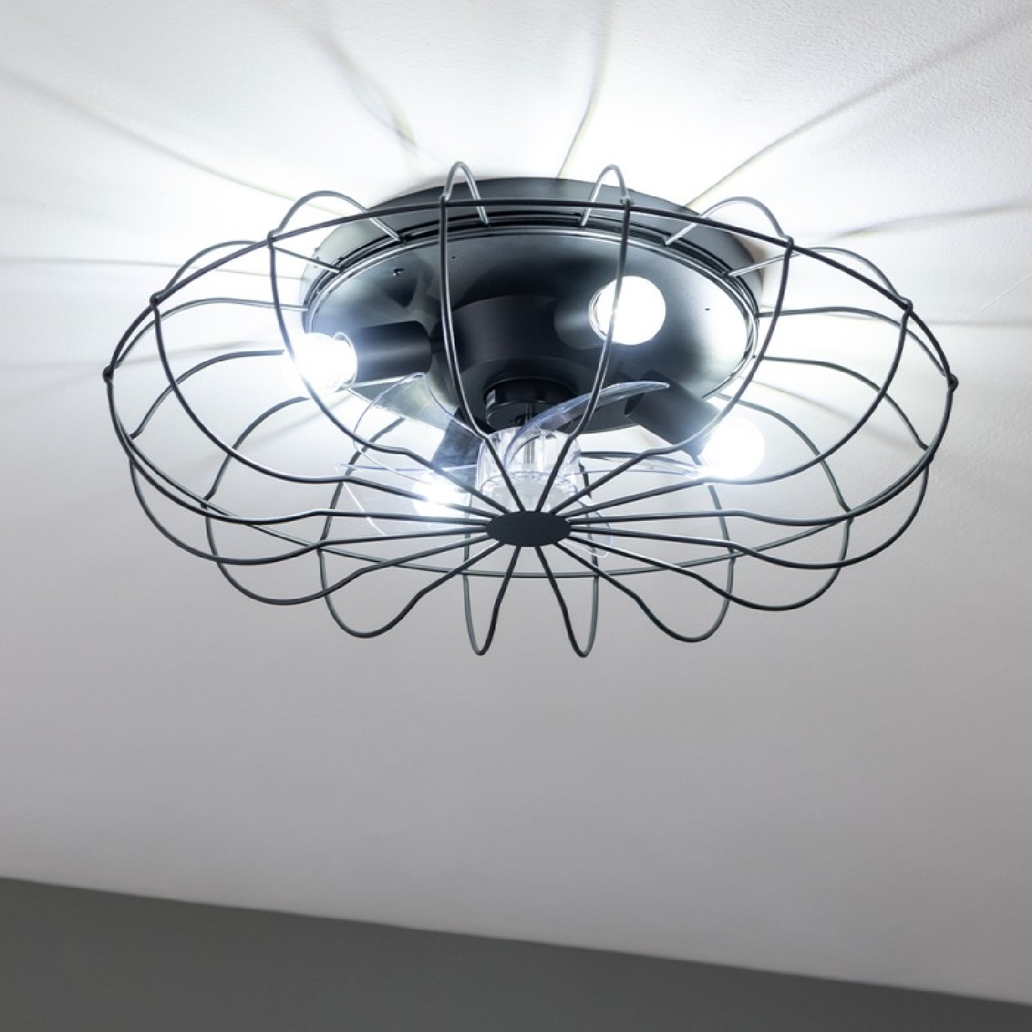 Schwarzer Deckenventilator mit Käfigdesign, beleuchtet von drei Lichtern.