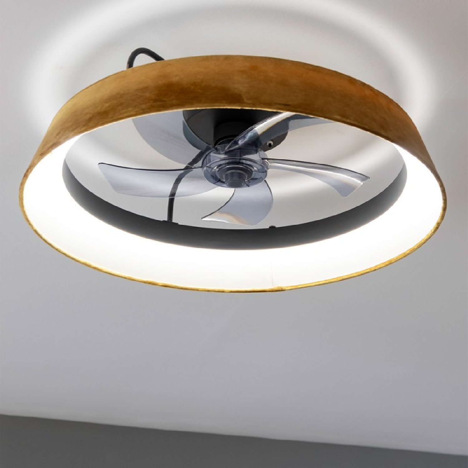 Un ventilatore a soffitto con un paralume marrone e un apparecchio di illuminazione bianco.