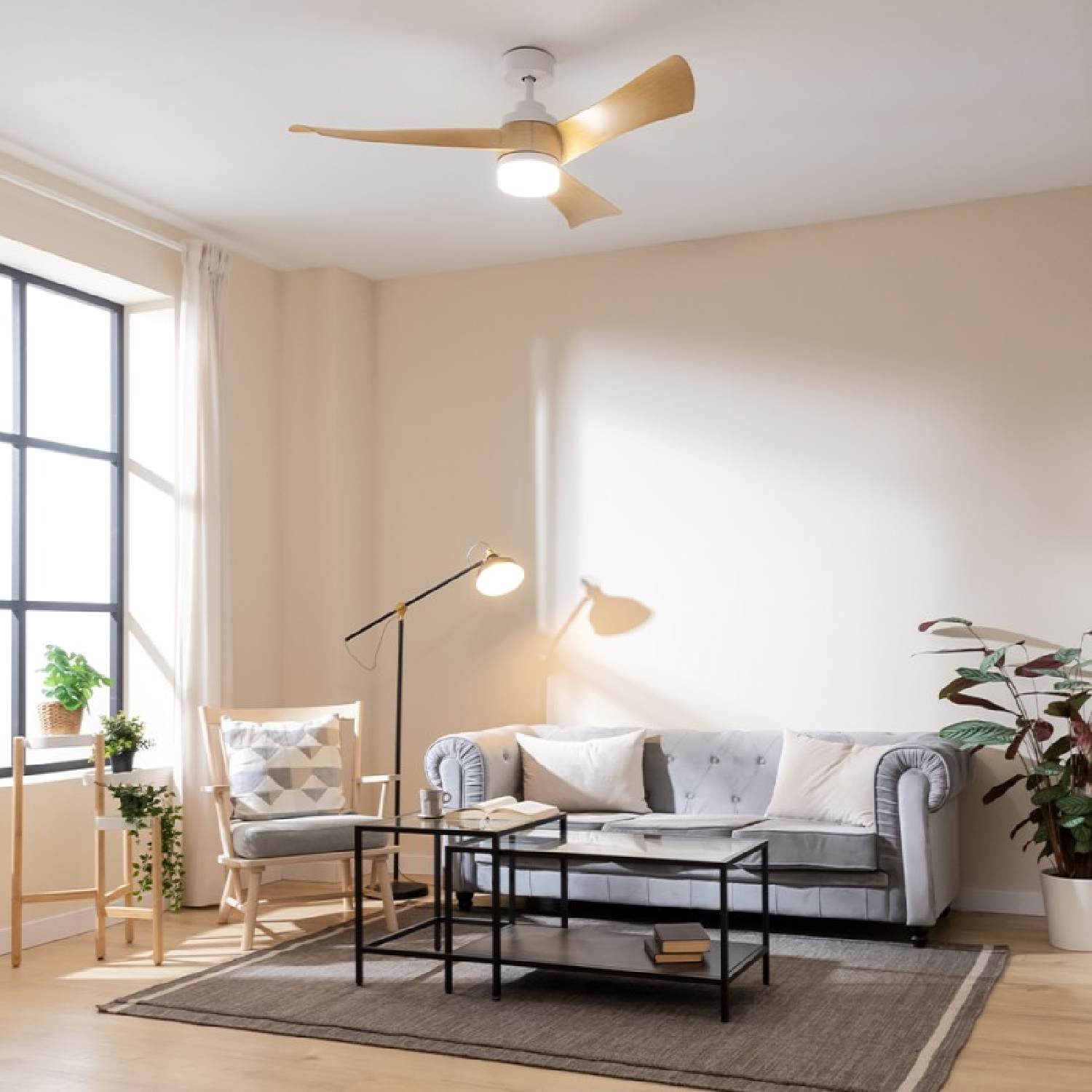Wohnzimmer mit Deckenventilator, Sofa, Tisch und Stuhl. Fenster, Pflanzen und Lampe.
