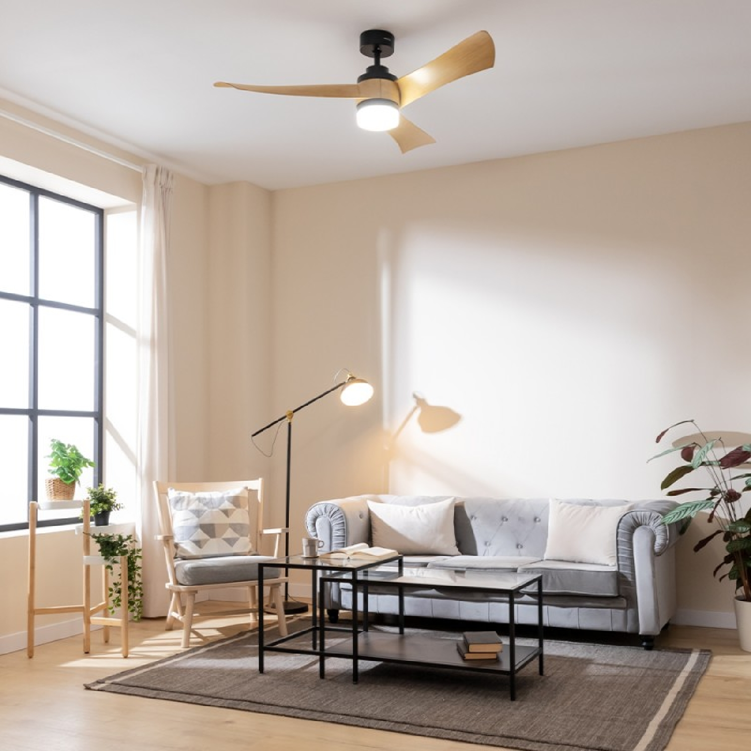 Soggiorno con divano, poltrona, tavolino, ventilatore e finestra. Muri e tappeto beige.