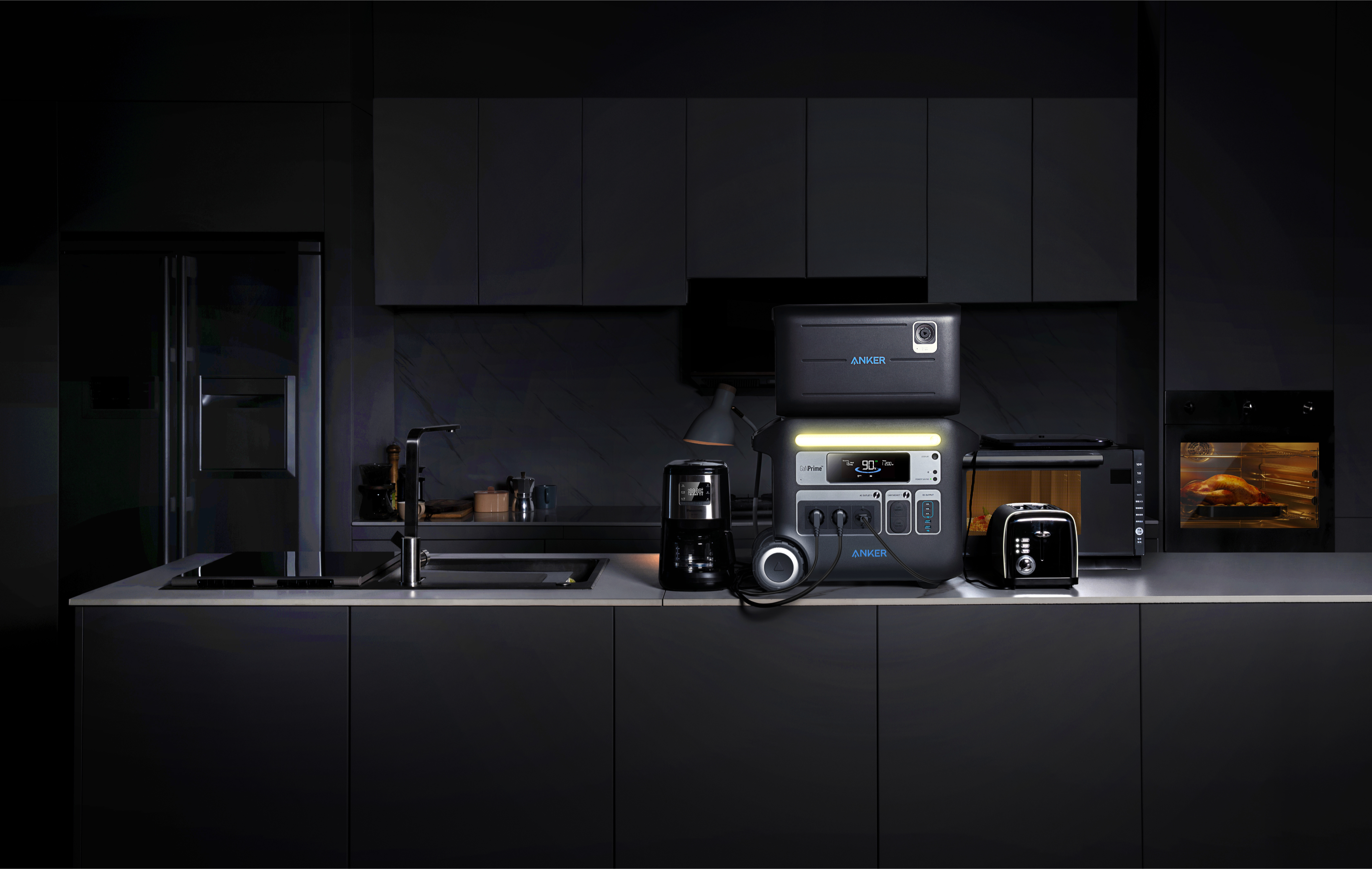 Układ kuchni ze stacjami zasilania, urządzeniami i czarnymi szafkami. Prezentuje nowoczesną, ciemną estetykę.