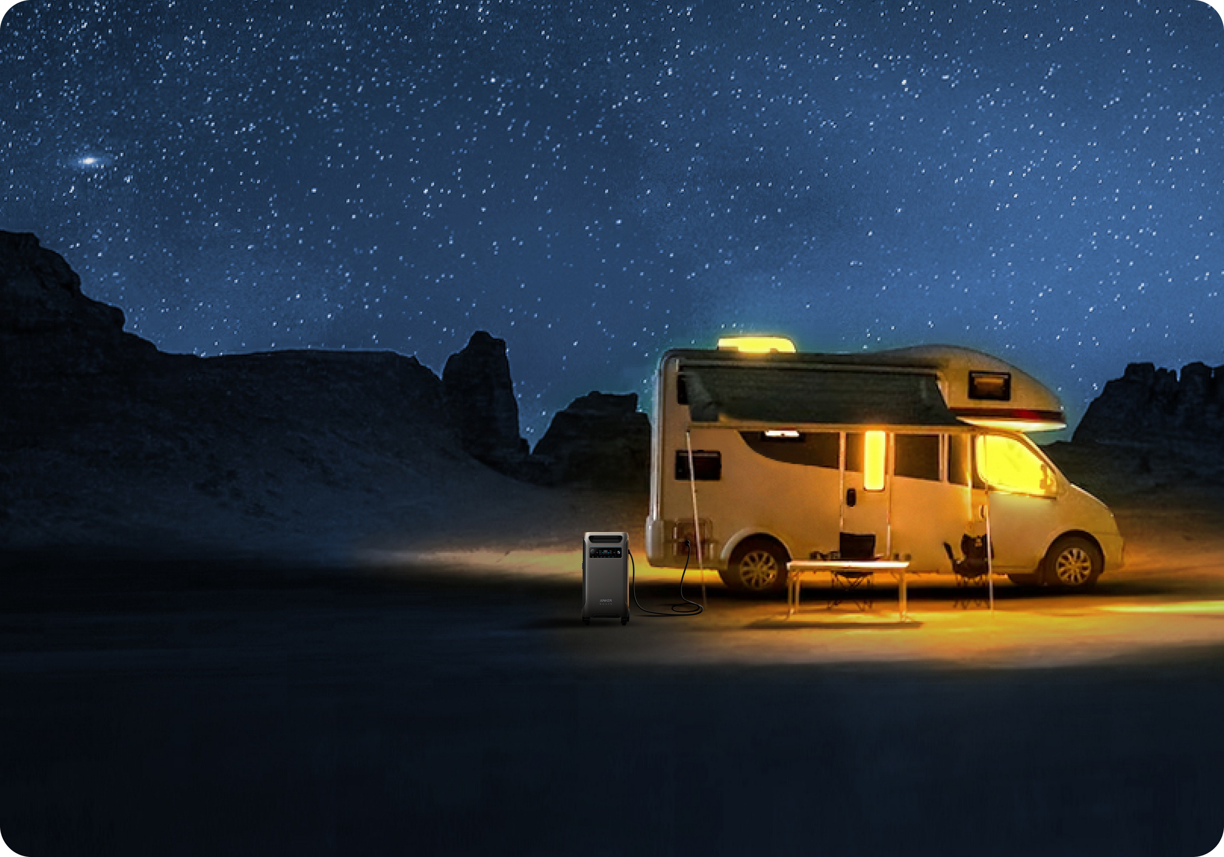 Kamper zaparkowany w nocy pod gwiaździstym niebem, z generatorem i stołem.