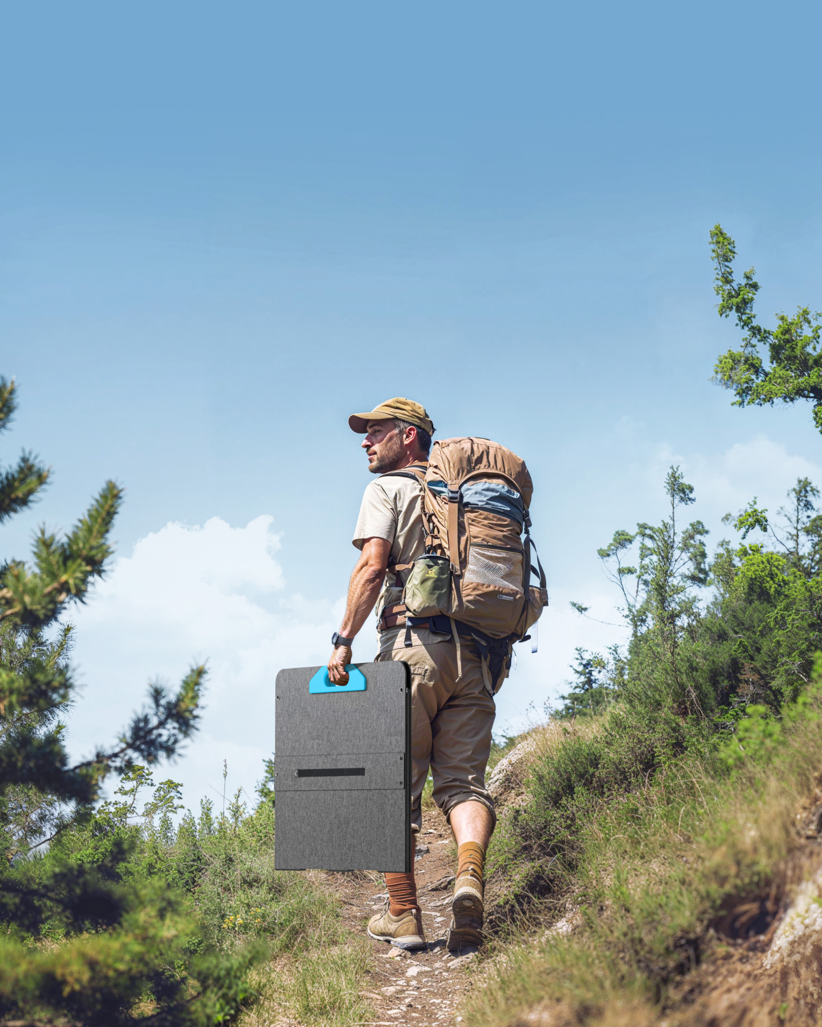 Mężczyzna wchodzi na wzgórze, niosąc plecak i składany panel słoneczny.