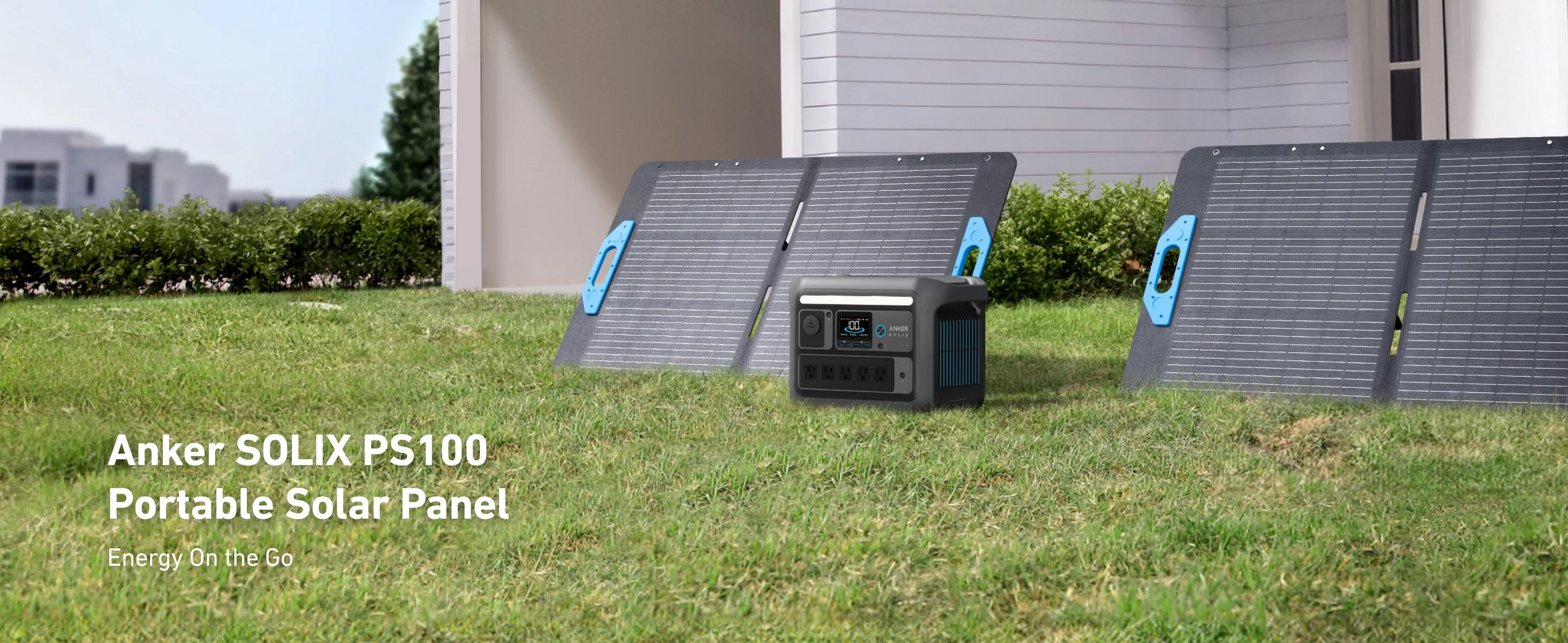 Panele słoneczne Anker i stacja zasilania na trawie. Panele otwarte. Biały dom w tle.