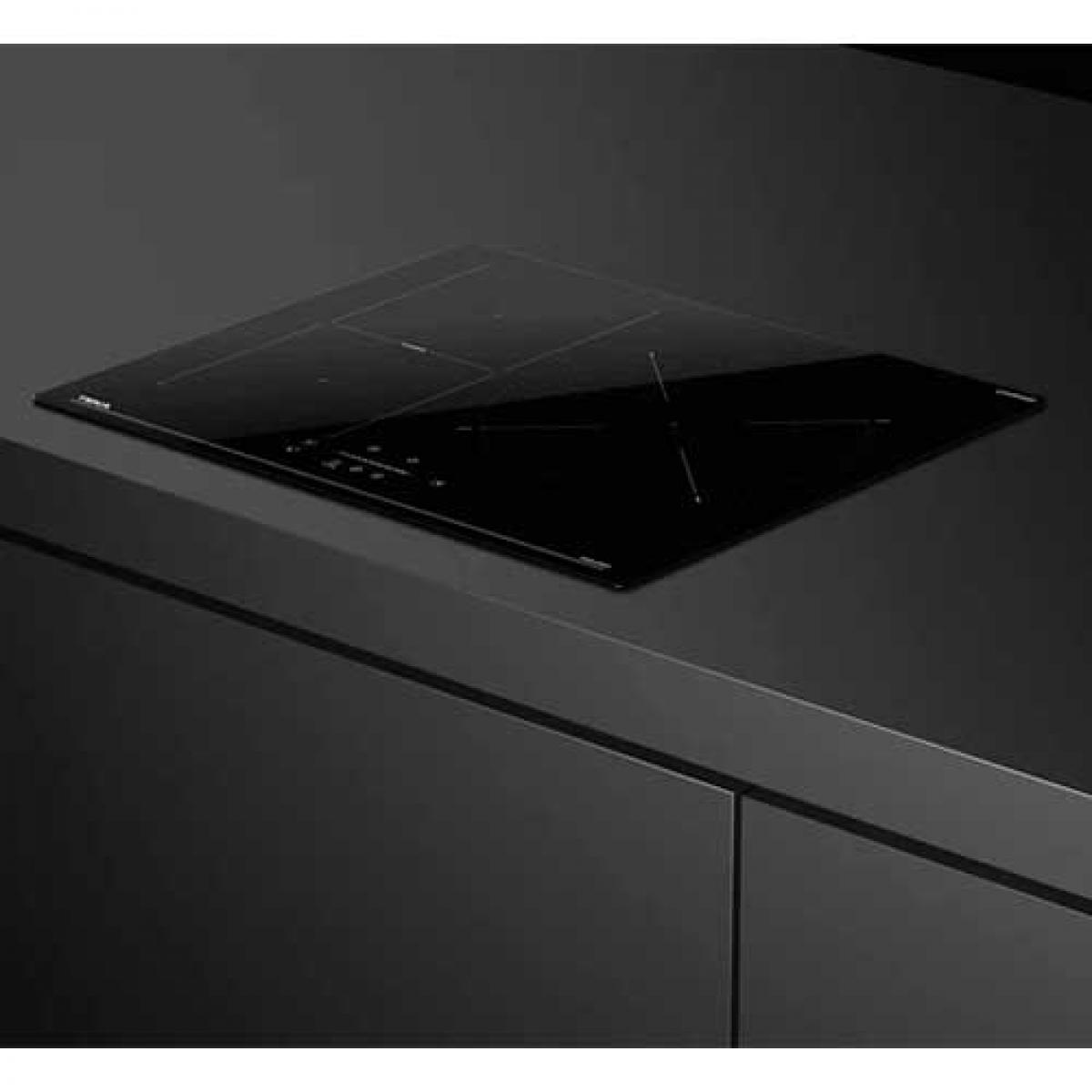 Czarna płyta indukcyjna na ciemnym blacie, o minimalistycznym designie.