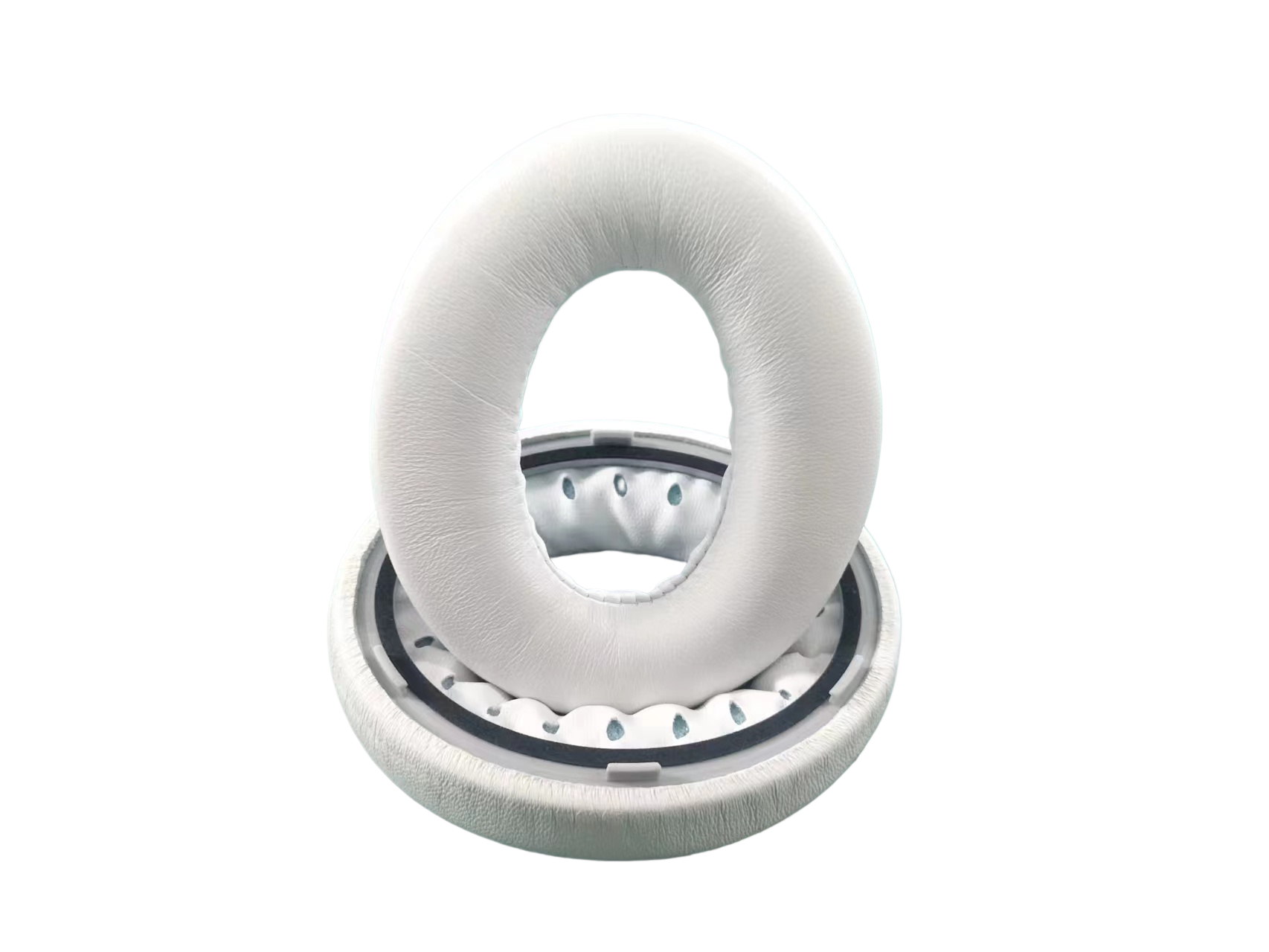 Białe nauszniki słuchawek. Dwa ułożone na czarnym tle. Okrągły kształt.