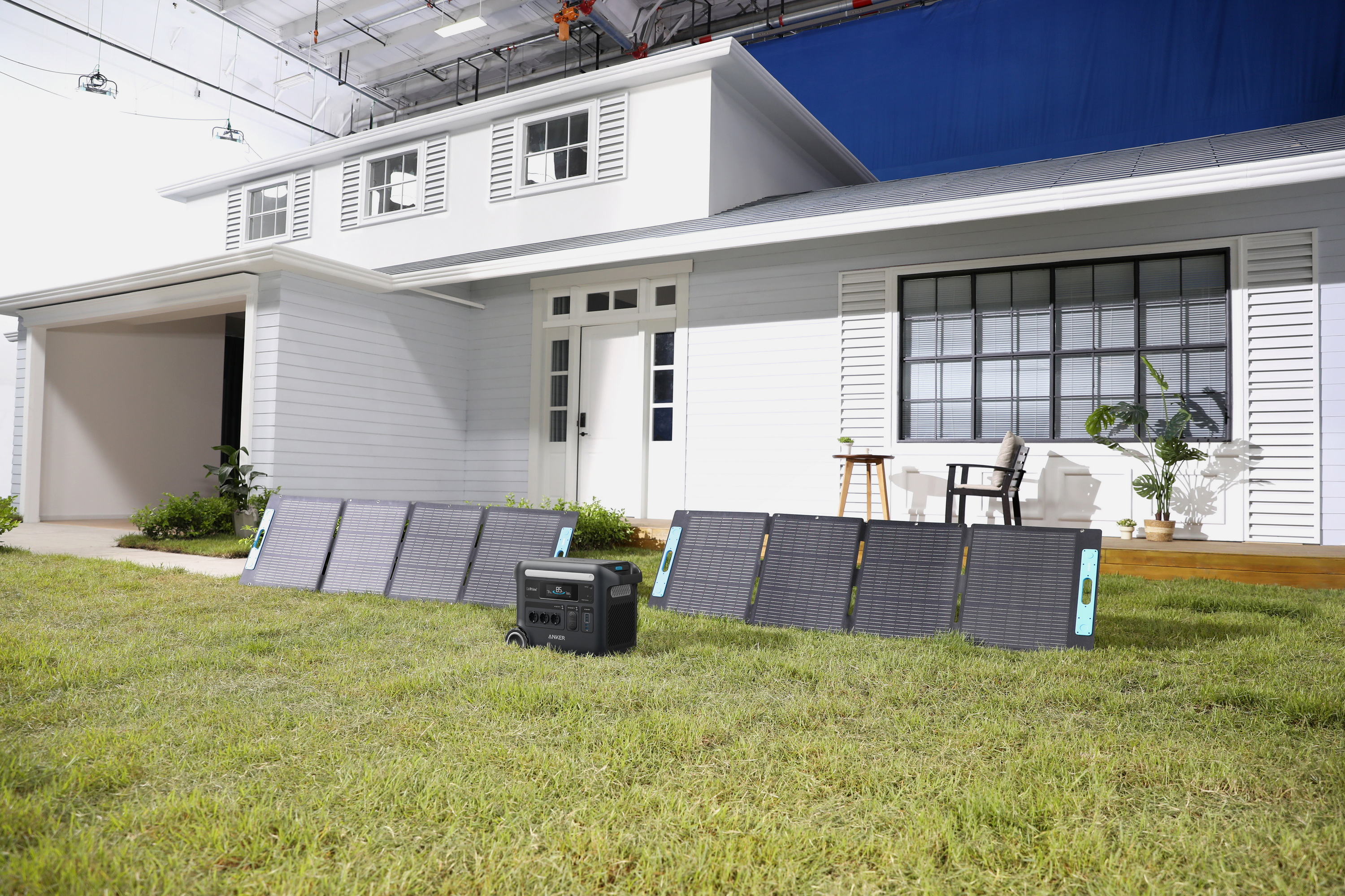 Dom z panelami słonecznymi na trawie. Obecny również generator.