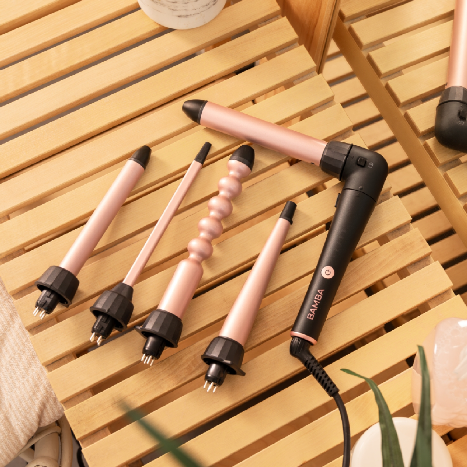 Strumenti per arricciare i capelli su superficie in legno. Include arricciacapelli e accessori.