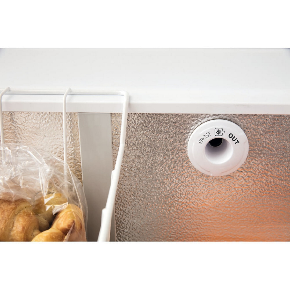 Interno del congelatore. Contenitore bianco con pane, contenitore bianco e uscita sbrinamento.