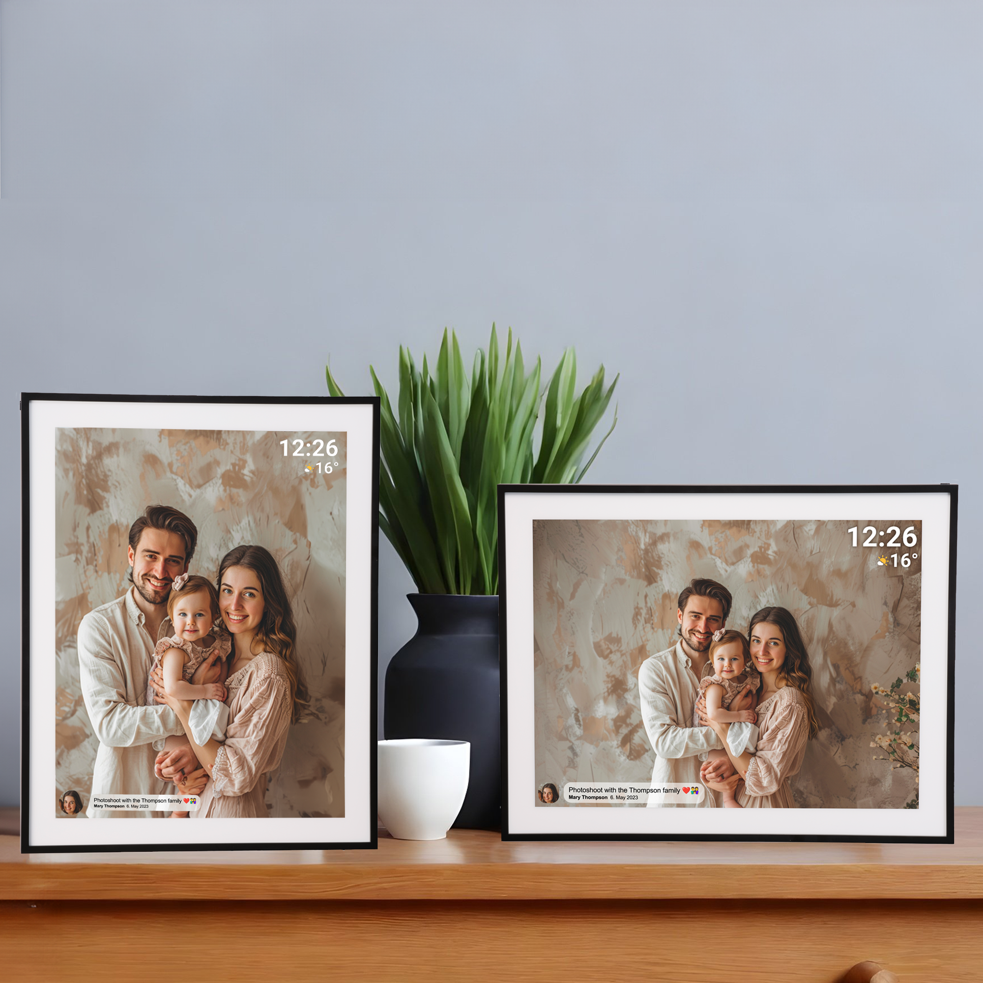 Dwa oprawione zdjęcia rodzinne na drewnianym stole, z rośliną w wazonie i białym kubkiem w pobliżu.