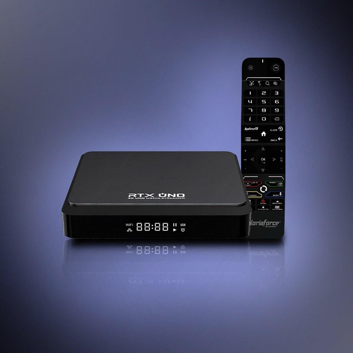 Schwarze TV-Box und Fernbedienung auf blauer Oberfläche. Box zeigt die Zeit 88:88, Fernbedienung hat Tasten.