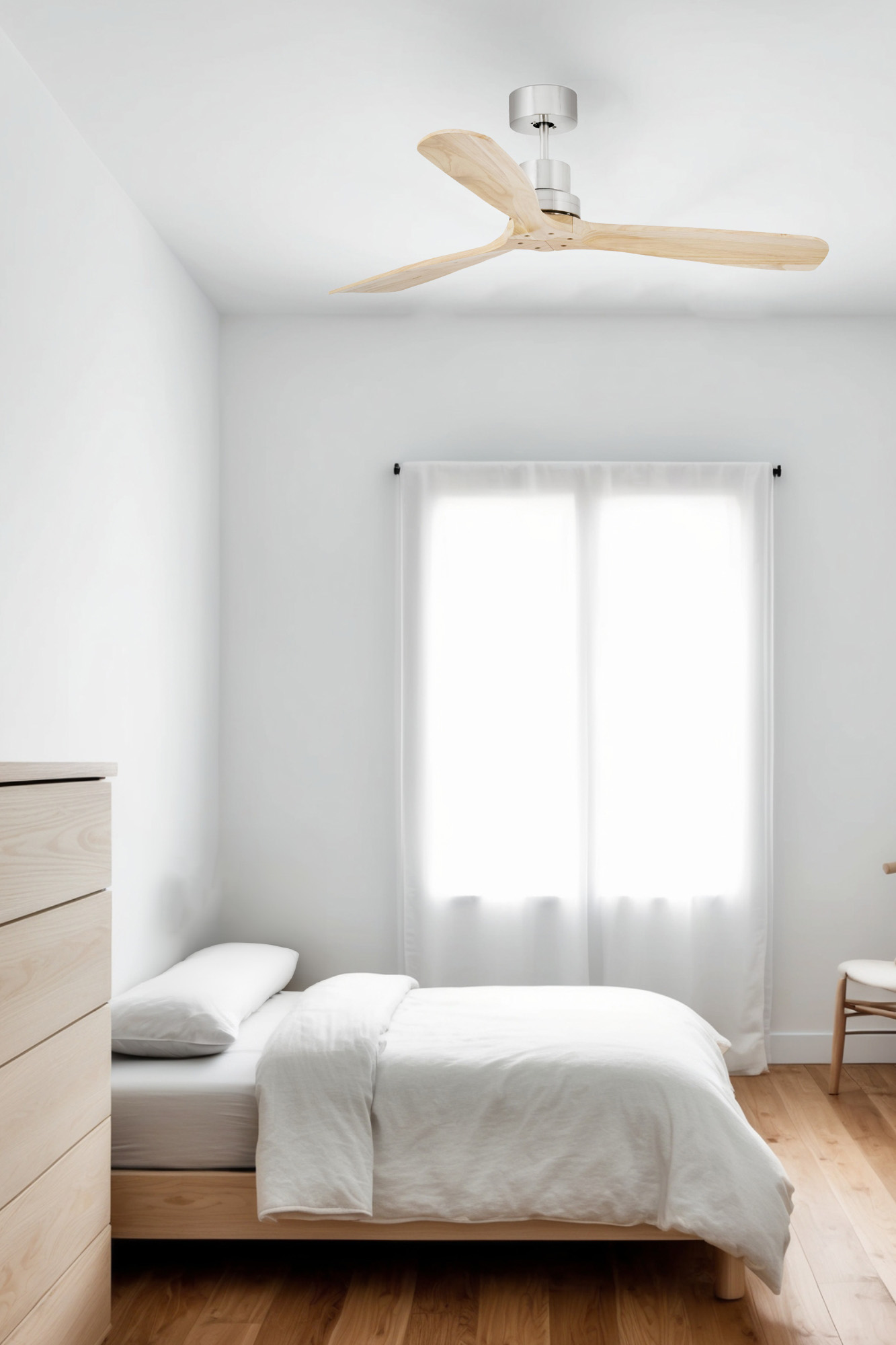Camera da letto con letto, cassettiera, ventilatore a soffitto e finestra con tende bianche.