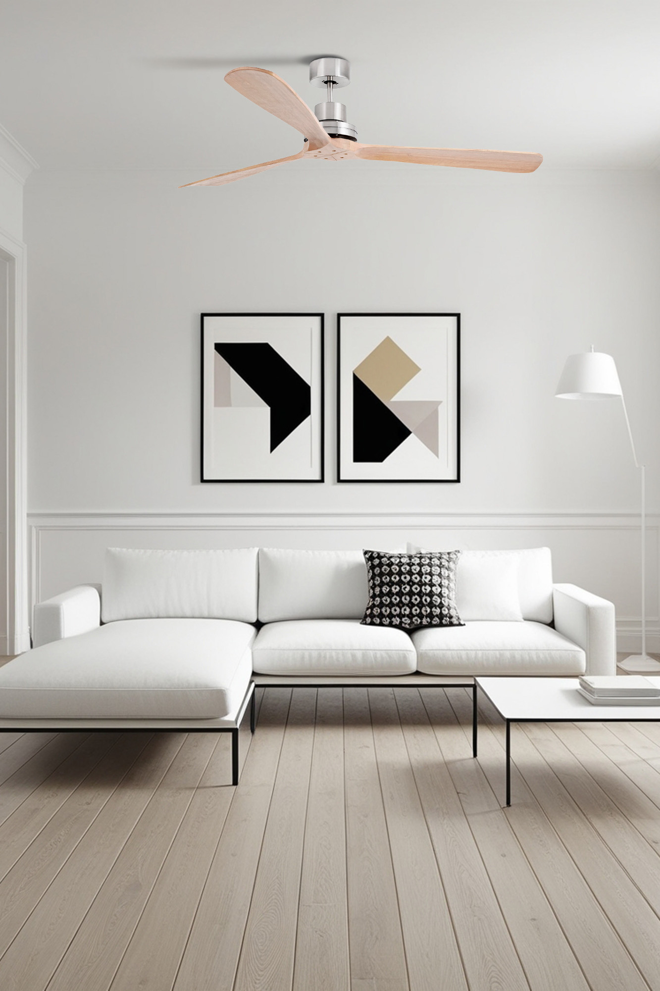 Innenraum mit weißem Sofa, zwei gerahmten abstrakten Kunstwerken und Deckenventilator.