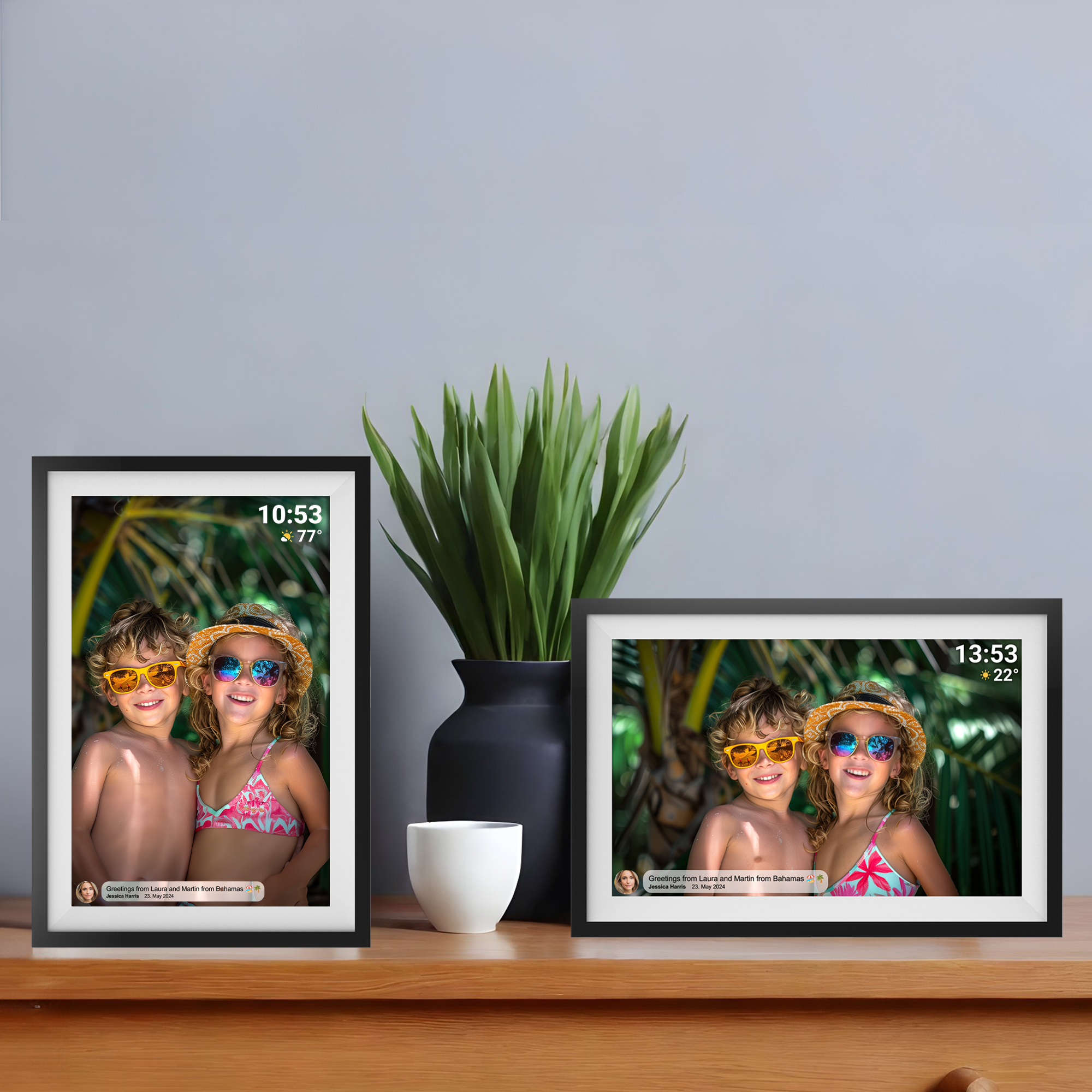 Deux photos encadrées d'enfants, un vase avec une plante et une tasse blanche sur une surface en bois.