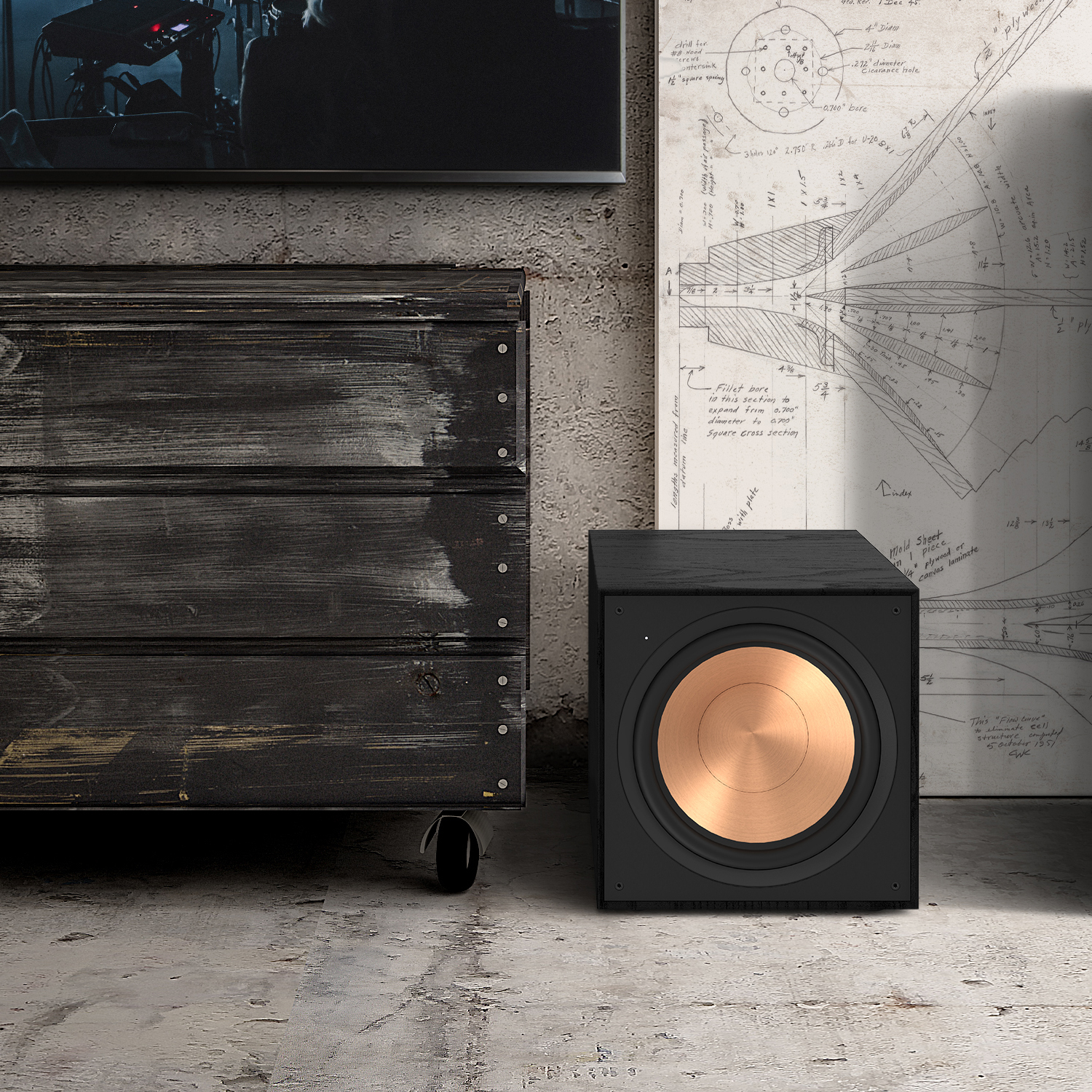 Schwarzer Subwoofer mit Kupferlautsprecher. Daneben ein schwarzer Schrank auf Rollen.
