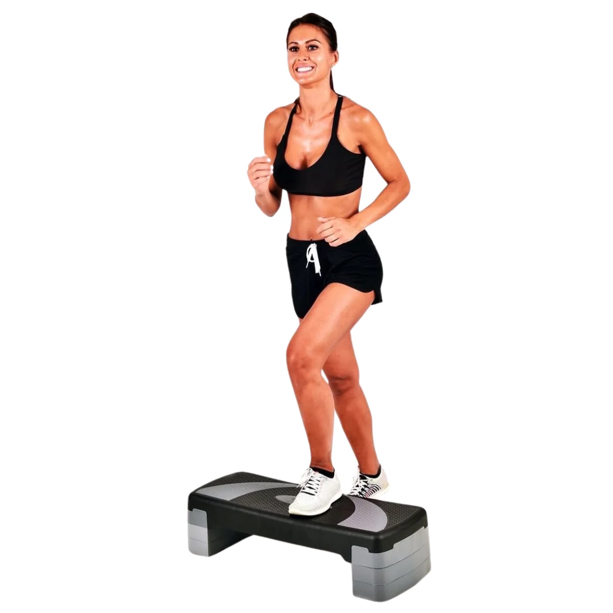 Vrouw stapt op een zwart en grijs step platform, draagt sportkleding.