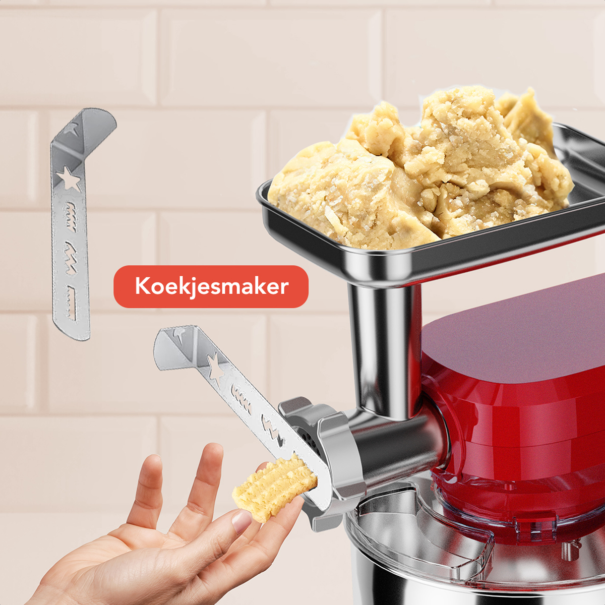 Een rode en zilveren keukenmachine met een stervormige koekjessnijder. Een hand houdt een koekje vast.