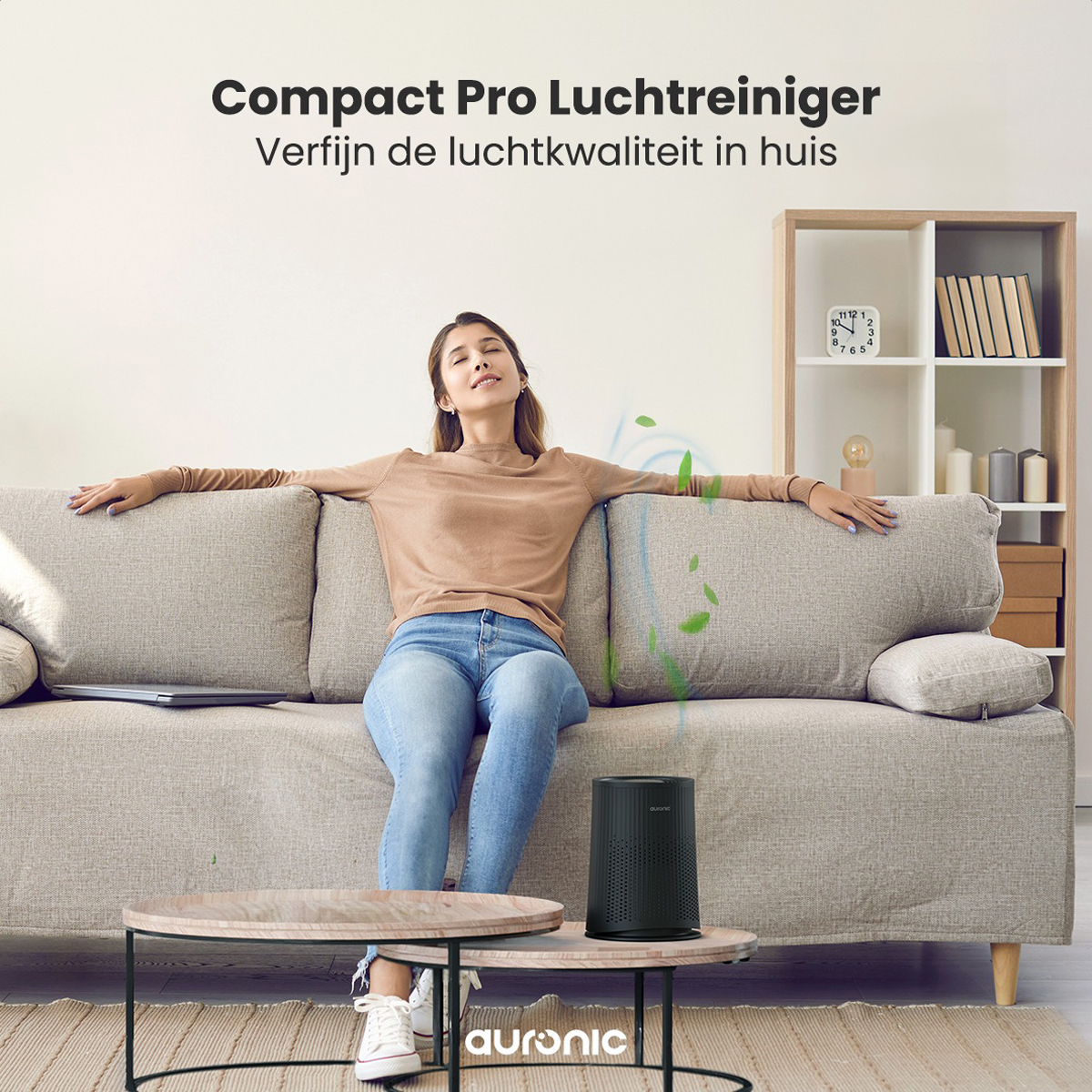 A woman relaxes on a sofa, with an air purifier on the floor, in a living room.