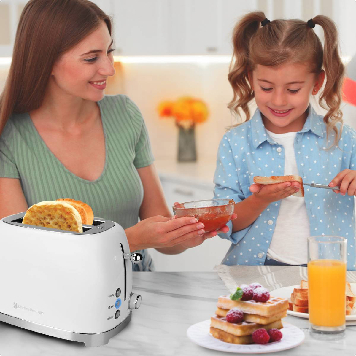 Eine Frau und ein Mädchen machen Frühstück. Ein weißer Toaster und Waffeln sind sichtbar.