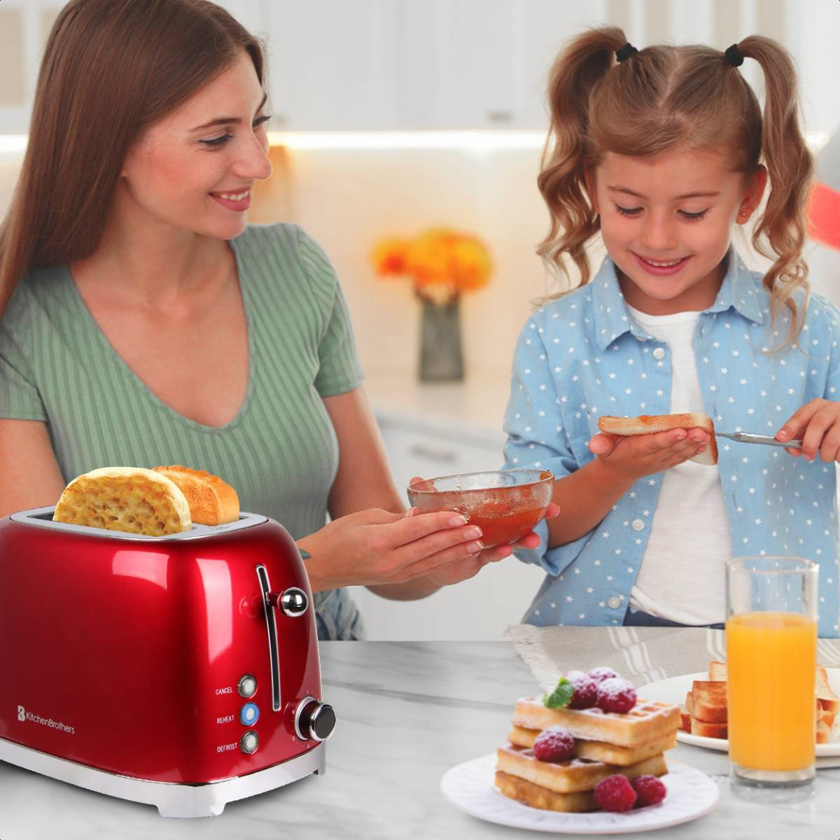 Frau und Kind toasten mit rotem Toaster, Waffeln und Orangensaft.