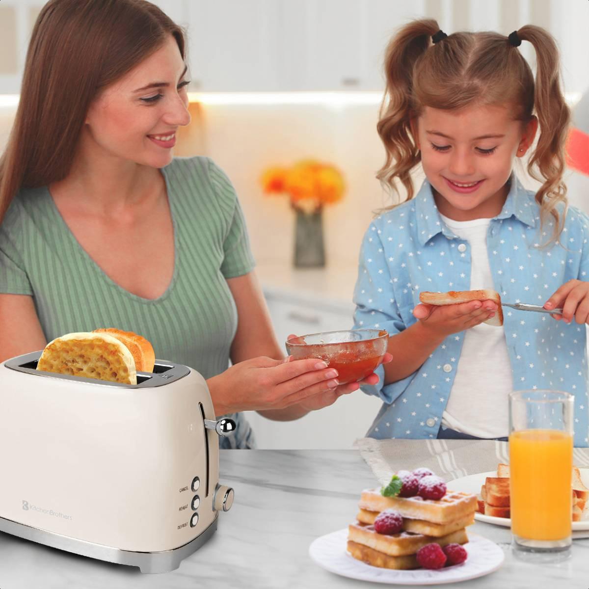 Eine Frau und ein Mädchen toasten mit cremefarbenem Toaster, Waffeln, Marmelade und Saft.